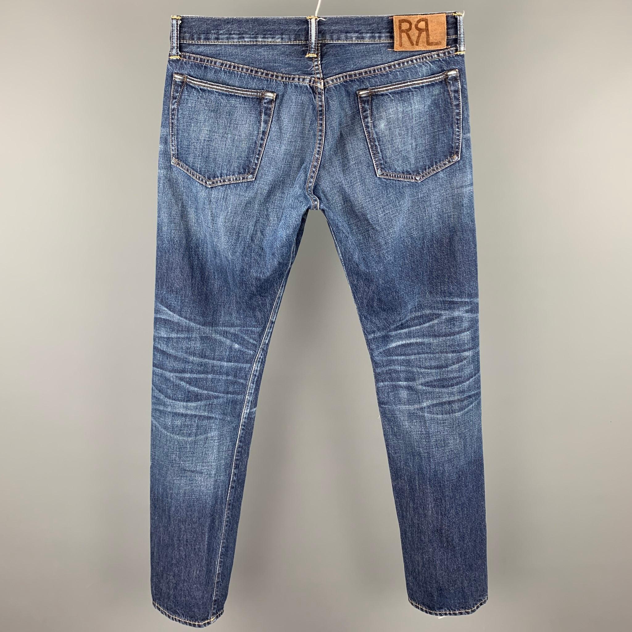 RRL by RALPH LAUREN jeans comes in a indigo washed selvedge denim featuring a slim fit, contrast stitching, and a button fly closure. Made in USA.

Good Pre-Owned Condition.
Marked: 33x32

Measurements:

Waist: 34 in.
Rise: 10 in.
Inseam: 33 in. 