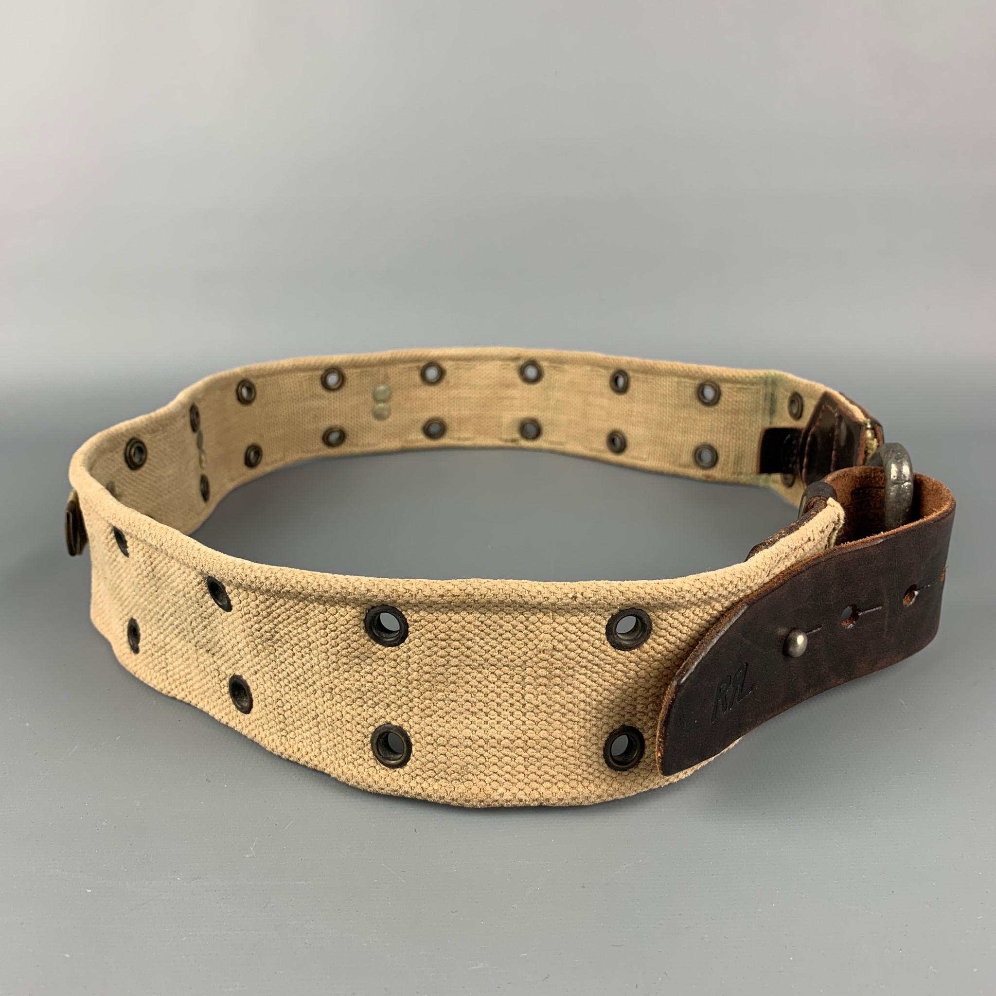 RRL by RALPH LAUREN belt comes in a brown & khaki distressed canvas featuring a leather trim, grommet details, back strap design, and a silver tone buckle. Made in USA. 

Very Good Pre-Owned Condition.
Marked: 34

Length: 45 in.
Width: 2 in.
Fits:
