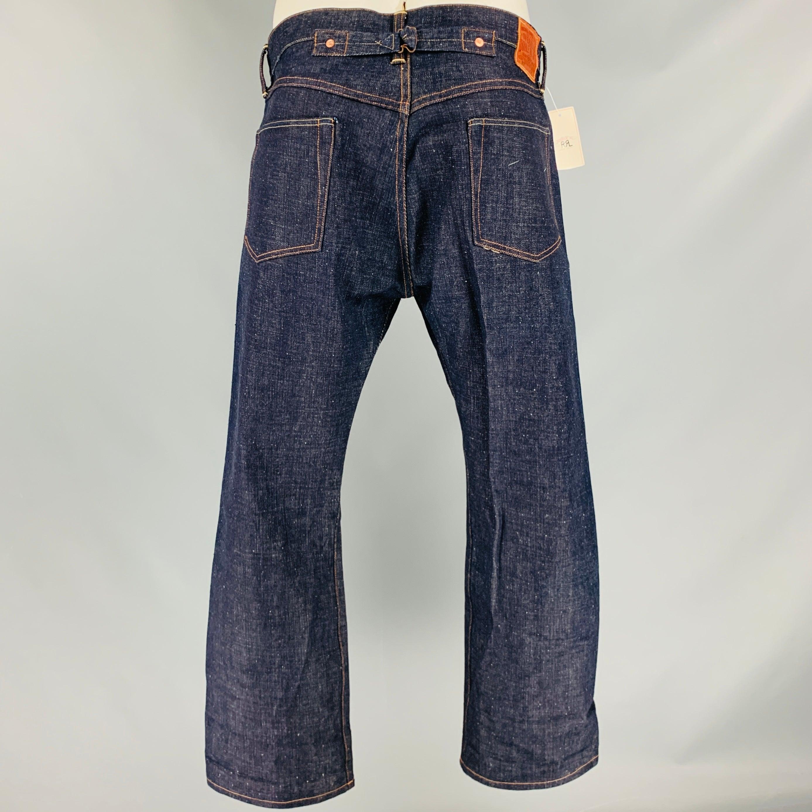RRL by RALPH LAUREN jeans
in an indigo selvedge denim cotton fabric featuring yellow contrast stitching, back cinch, and button fly closure. Made in USA. Note: this item has been altered, please check the measurements.Excellent Pre-Owned Condition.