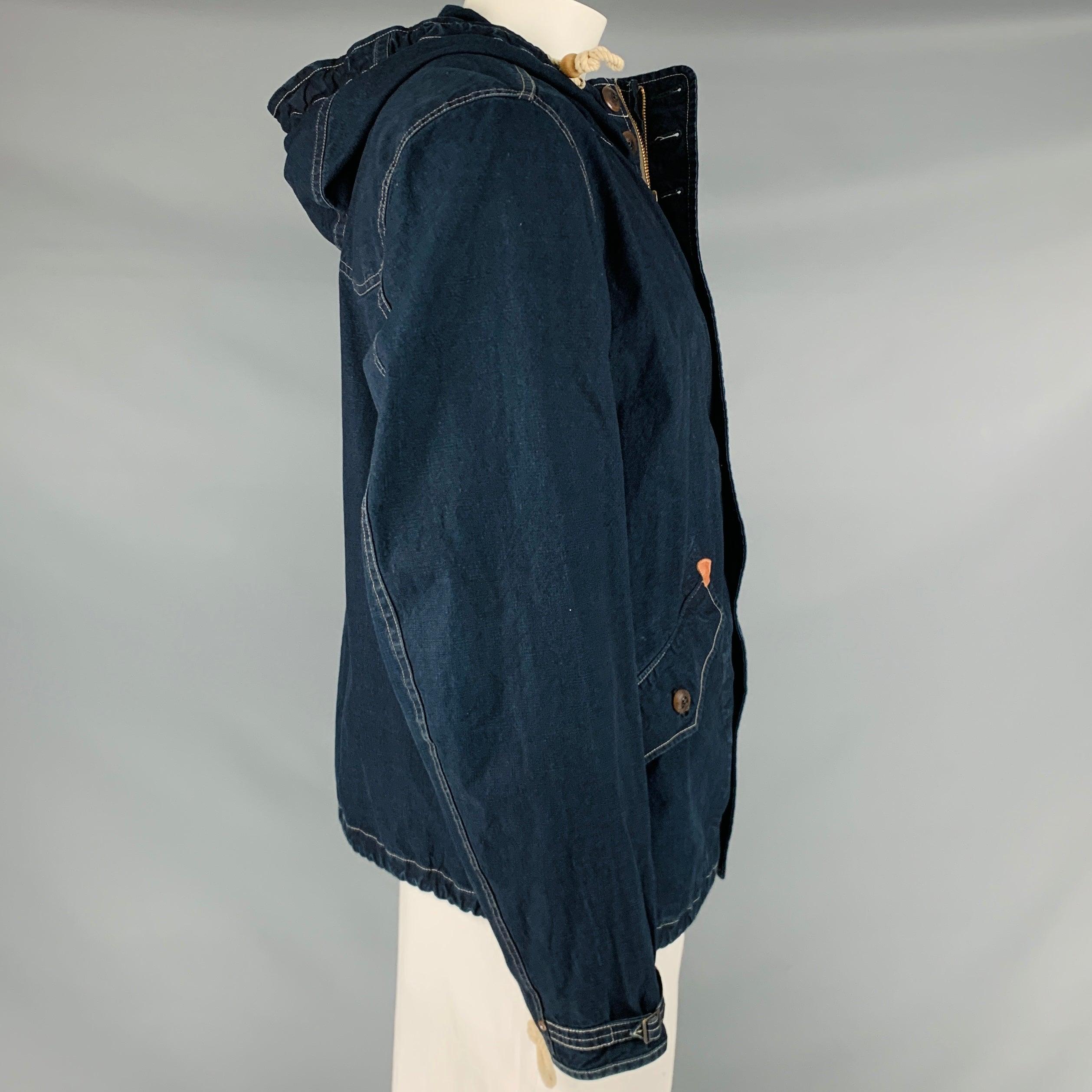 RRL by RALPH LAUREN jacket
in an indigo cotton fabric featuring a hooded style, two large button pockets with leather details, and zip up & button closure. Very Good Pre-Owned Condition. Minor signs of wear. 

Marked:   L 

Measurements: 
