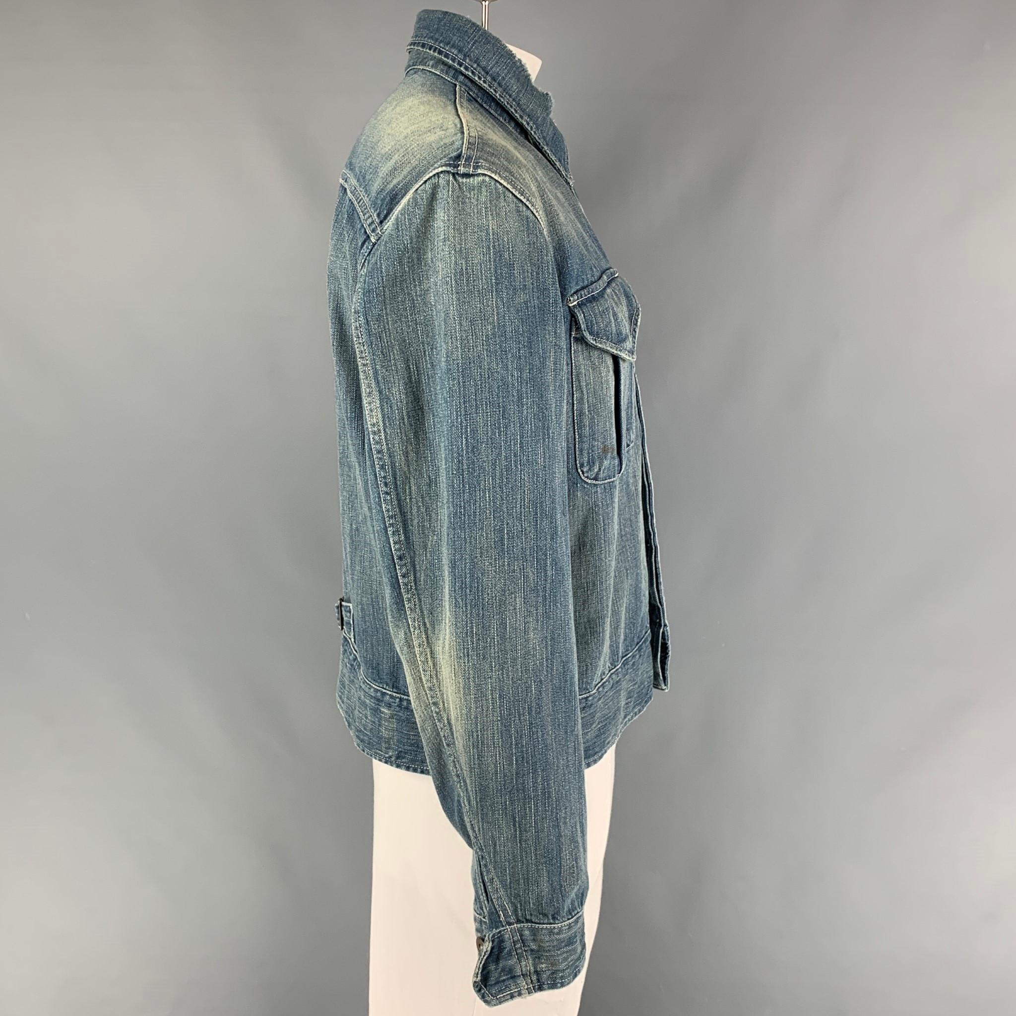 RRL by RALPH LAUREN jacket comes in a blue distressed cotton featuring two large front pockets, spread collar, contrast stitching, back strap detail, and a hidden placket closure. 

Very Good Pre-Owned Condition. Light marks at front.
Marked: