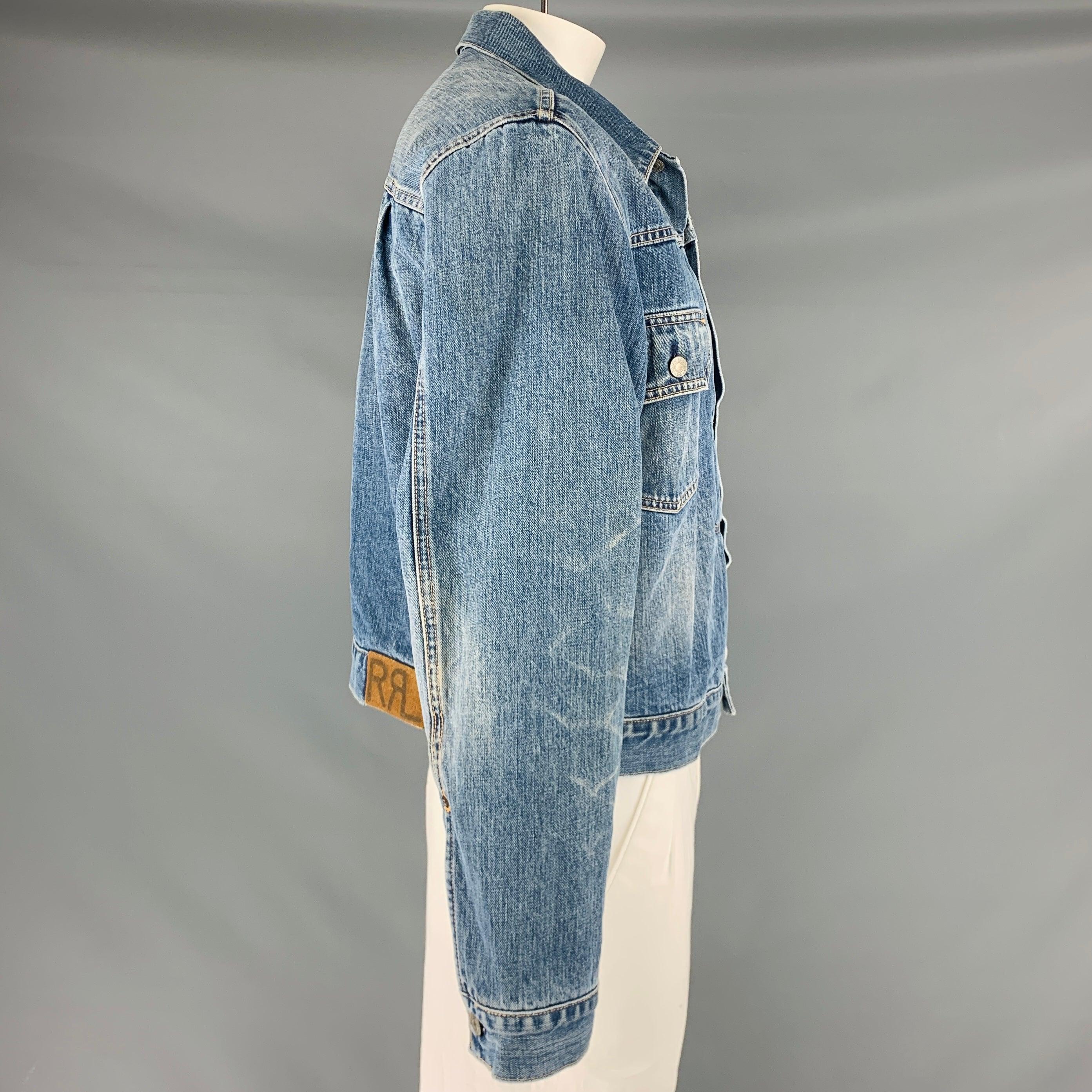 RRL by RALPH LAUREN jacket
in a blue wash denim fabric featuring a trucker style, plaid lining, two patch pockets, and a button closure. Very Good Pre-Owned Condition. Minor signs of wear. 

Marked:   XL 

Measurements: 
 
Shoulder: 19.5 inches