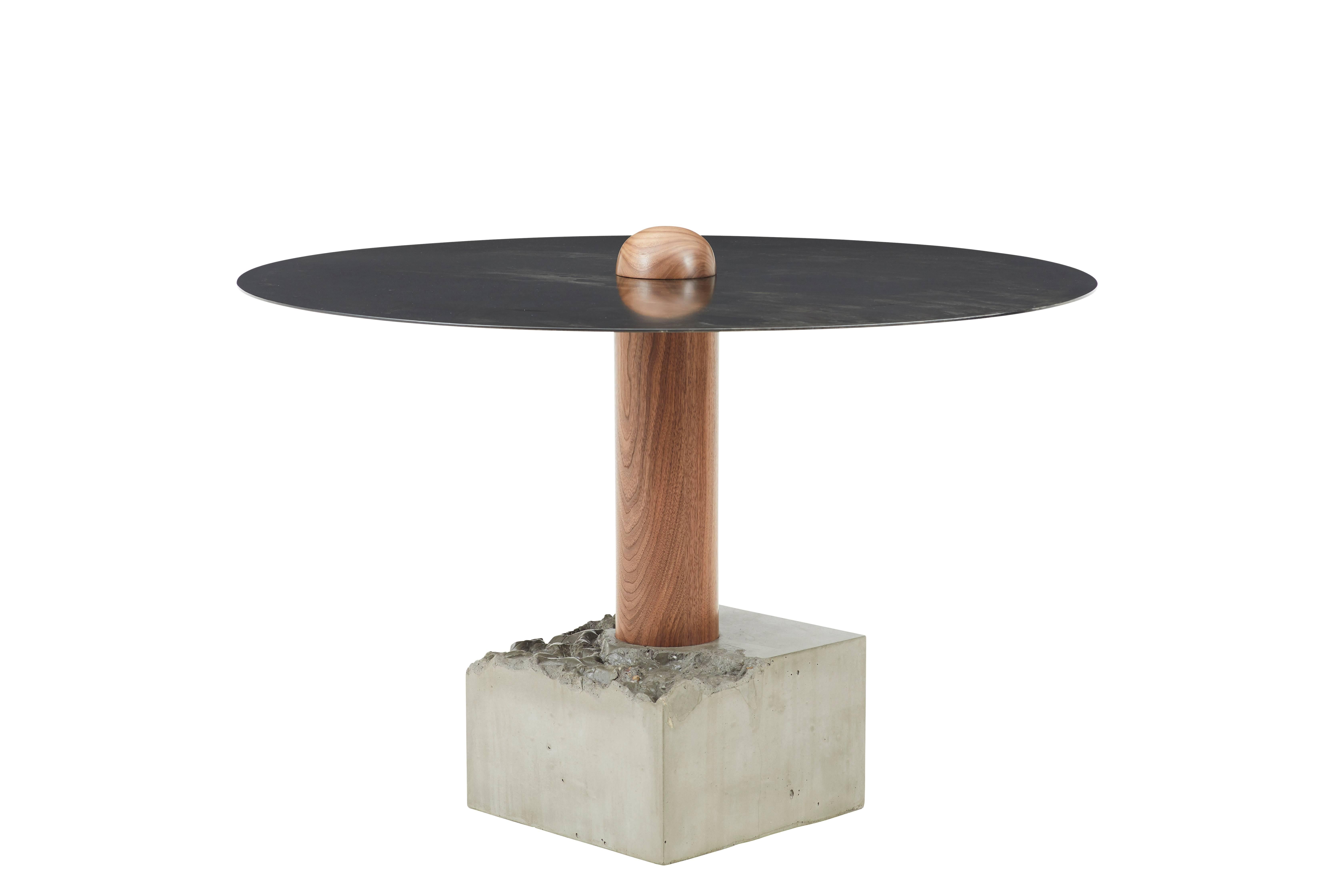 This round dining table is made of steel, solid walnut wood and cast-concrete. the base is cast to resemble a 