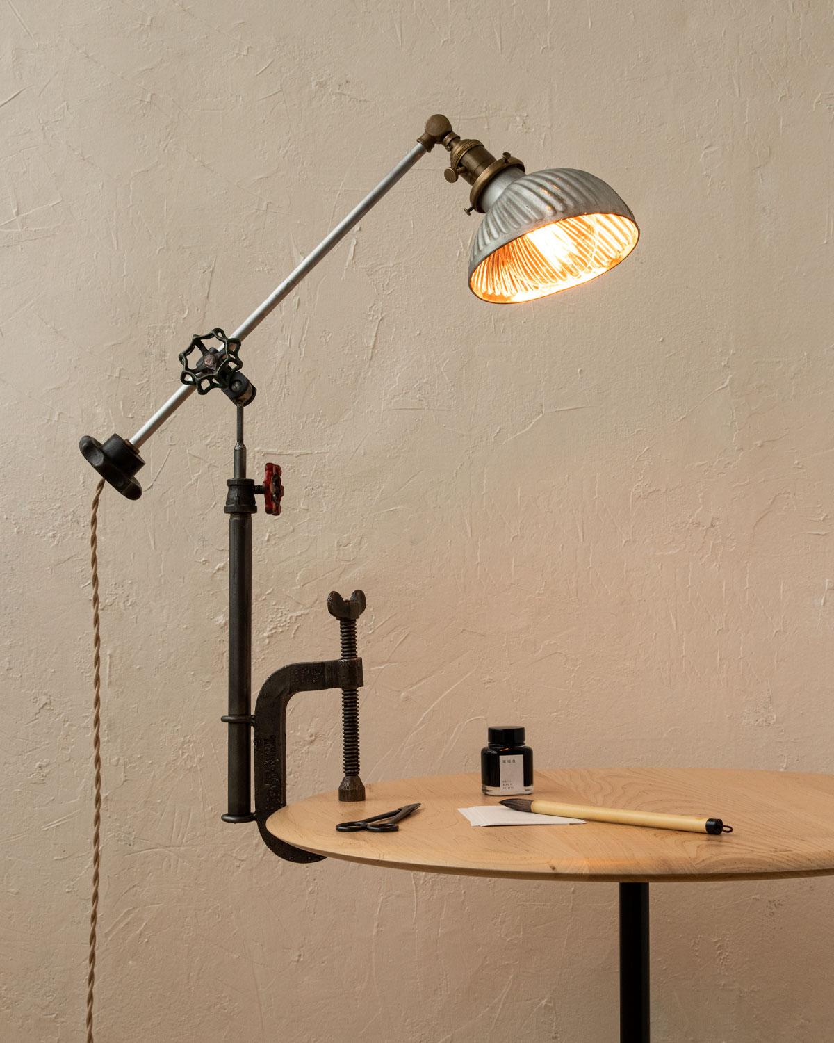 Robert True Ogden's one-of-a-like Found Object Lamps are made by hand in Philadelphia. Crafted from pieces and parts sourced locally and abroad, no two lamps are alike. 

This clamp lamp has a vintage asymmetrical painted glass shade with a