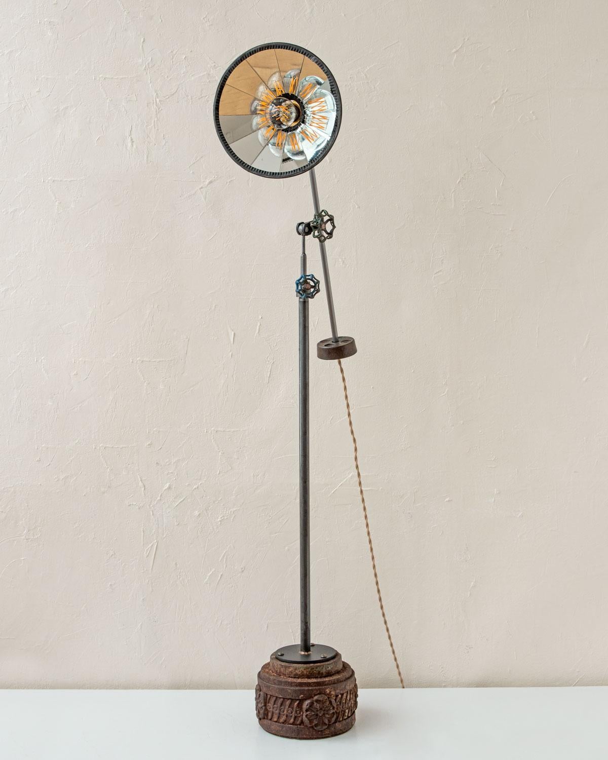 Robert True Ogden's one-of-a-like Found Object Lamps are made by hand in Philadelphia. Crafted from pieces and parts sourced locally and abroad, no two lamps are alike. 

This floor lamp has a ribbon glass mirrored shade with an oil-rubbed brass