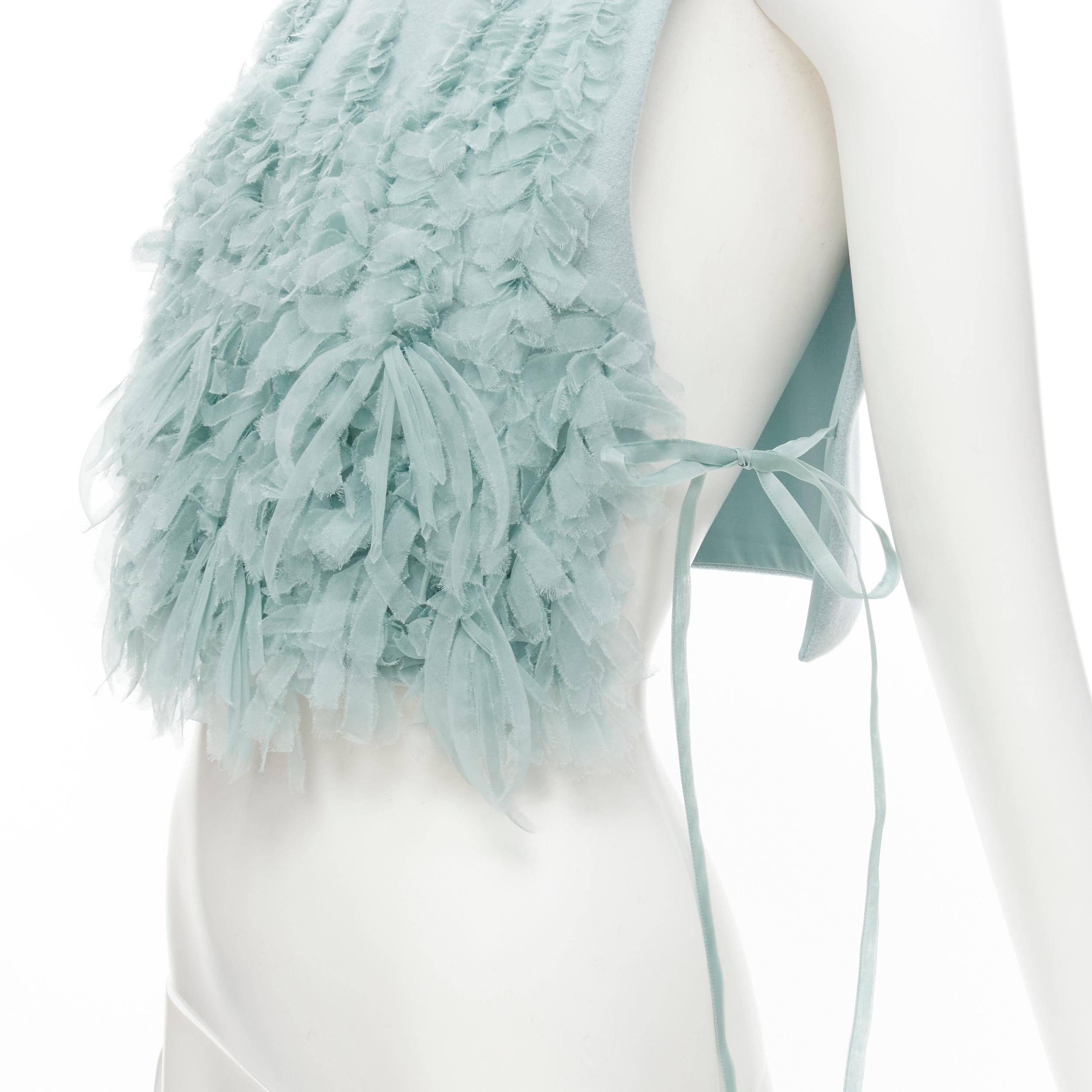 RUBAN Russia 100% wool light blue silk ruffle petal tie side cropped vest top XS 
Reference: LNKO/A01857 
Brand: Ruban Atelier 
Material: Wool 
Color: Blue 
Pattern: Solid 
Closure: Tie 
Extra Detail: Ribbon ties at sides. 
Made in: Russia