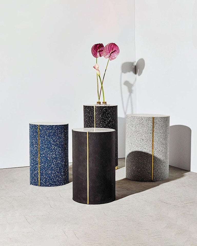 The rubber CYL side tables are a series of accent pieces which bring together recycled rubber on the exterior, cast together with concrete and a brass inlay. 

The exterior of the table is recycled rubber, fused together with a concrete table