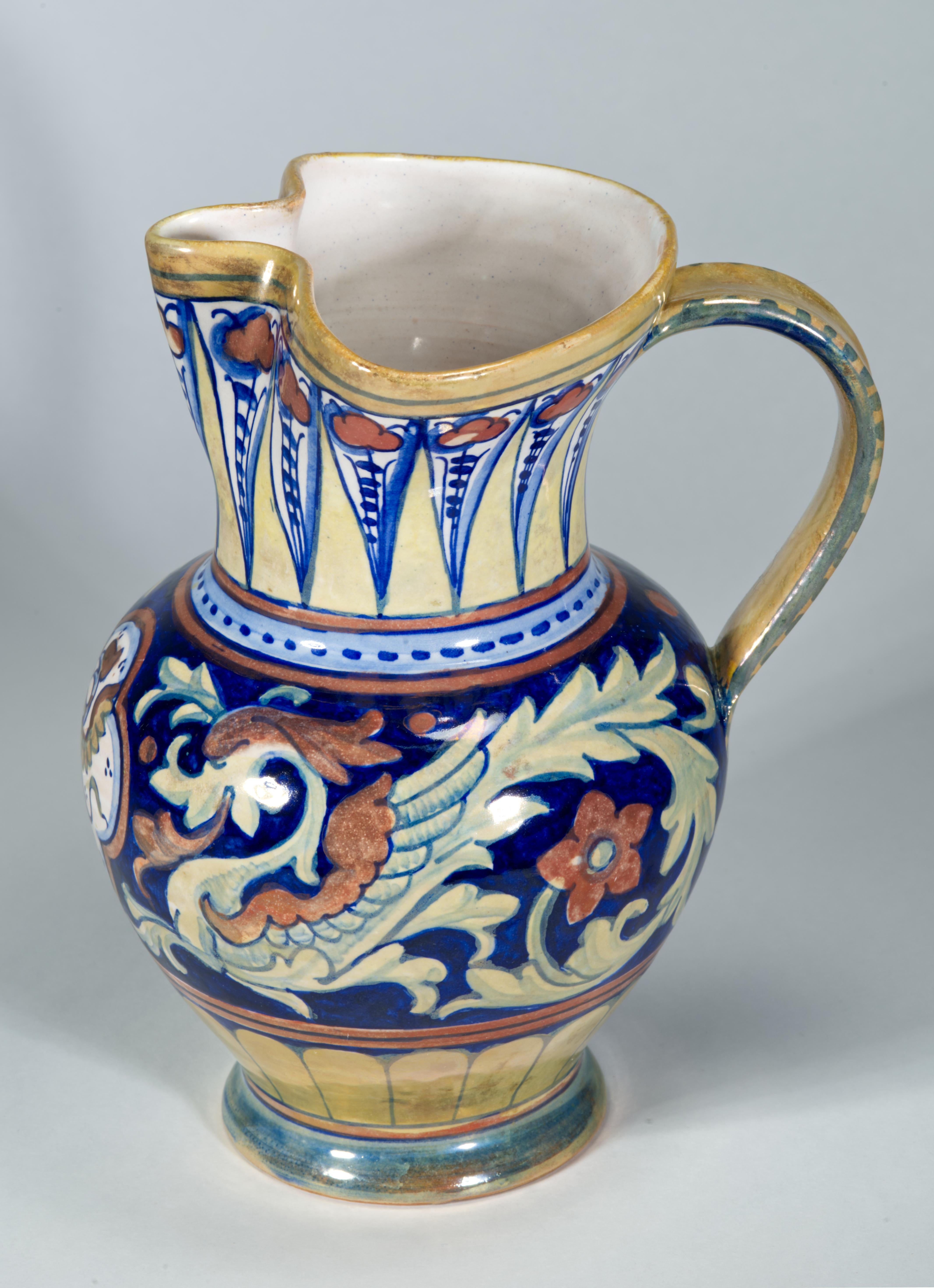 Striking ceramic Neo-Renaissance Rubboli pitcher vase features cobalt, red and gold Lustre majolica glaze decoration. Hand-painted decor follows the traditional shape of the piece, with abstract pattern accentuating the base and the top of the vase,