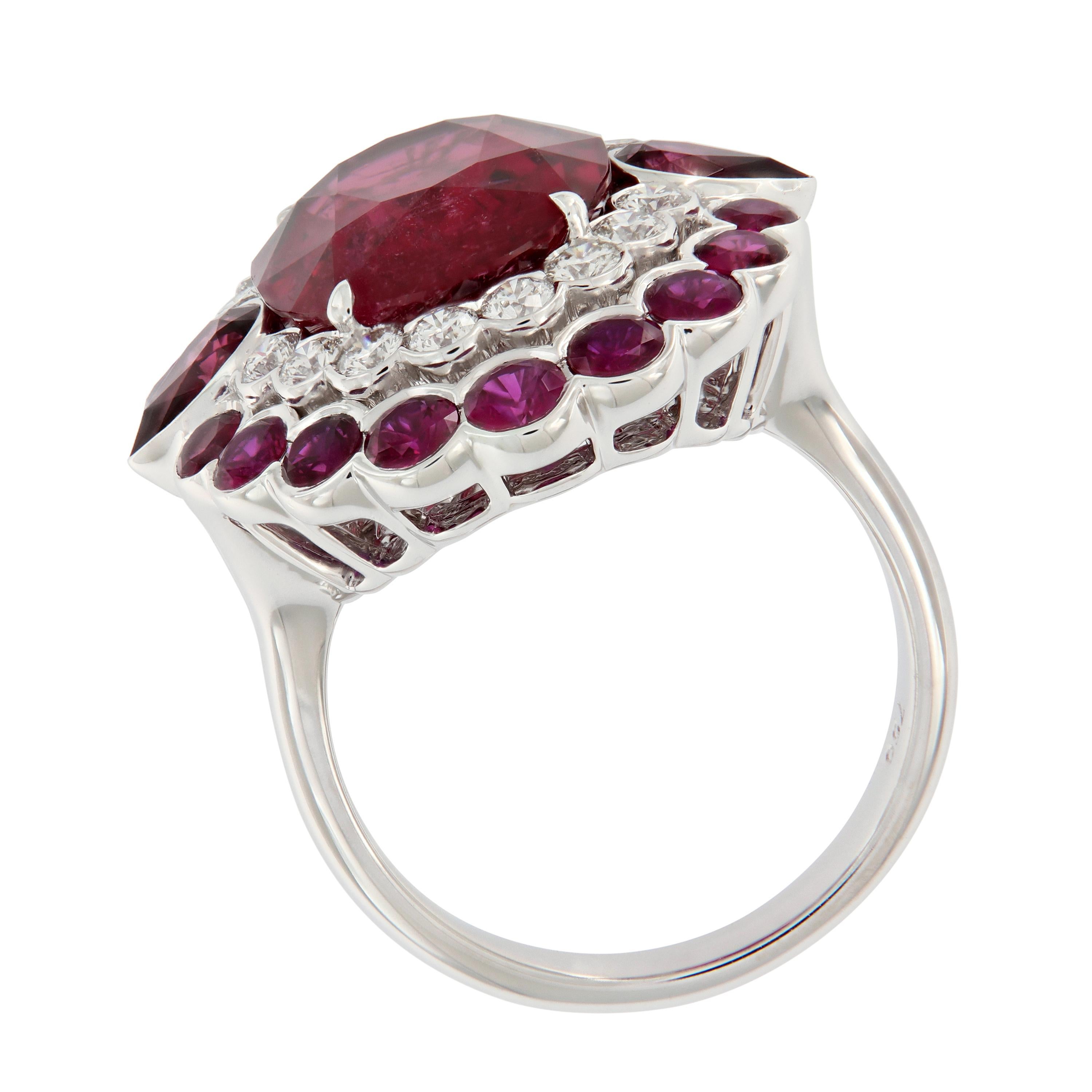 Glamorous 18k white gold cocktail ring showcases a large oval rubelite center accented with two pear shaped rubelites and  a halo of round diamonds and rubelites . surrounded by diamonds . Weigh 5.4 grams.

Rubelite 6.73 cttw
Diamonds 0.65 cttw