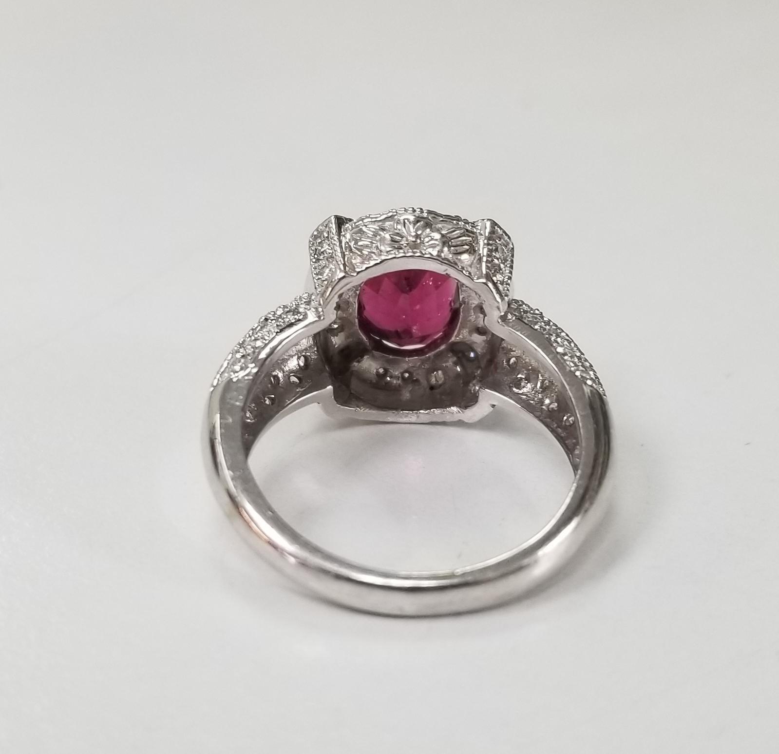 14k white gold tourmaline and diamond ring, containing 1 oval cut rubelite garnet weighing 2.27ct. and 54 round full cut diamonds of very fine quality weighing .55pts. set in a hand engraved setting.   This ring is a size 6.5 but we will size to fit