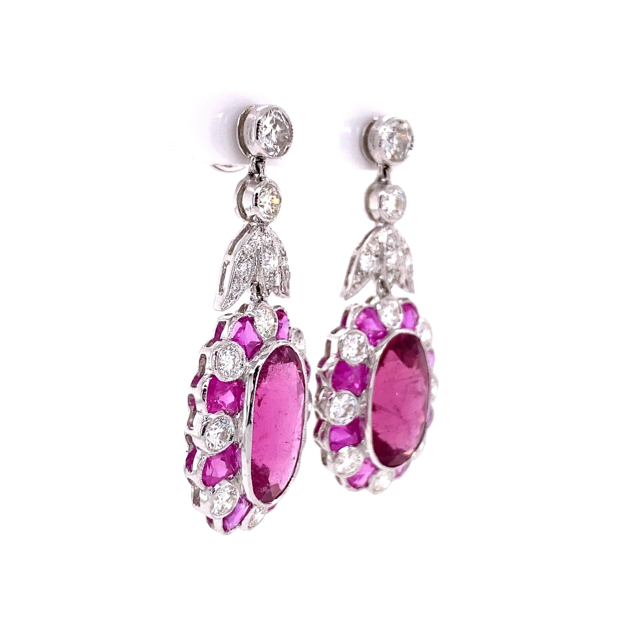 Beautiful and Finely detailed Cluster Dangle Earrings Hand set with two large oval Rubelite Tourmaline Gemstones, approx. 12.50tcw, 16 custom cut Natural Pink Sapphires, approx. 3.20tcw and 38 Old-cut Diamonds, approx. 3.00tcw. Post and butterfly