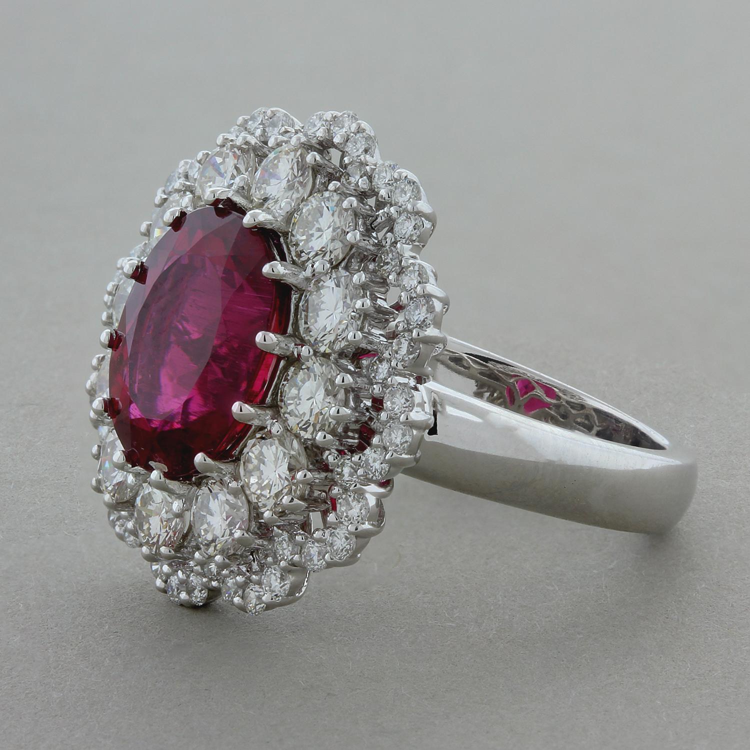 This lovely ring features a deep royal red rubelite tourmaline weighting 5.82 carats. It is accented by a double halo of 1.62 carats of round brilliant cut diamonds. Set in a 14K gold clustered flower setting.

Ring Size 7 (Sizable)
