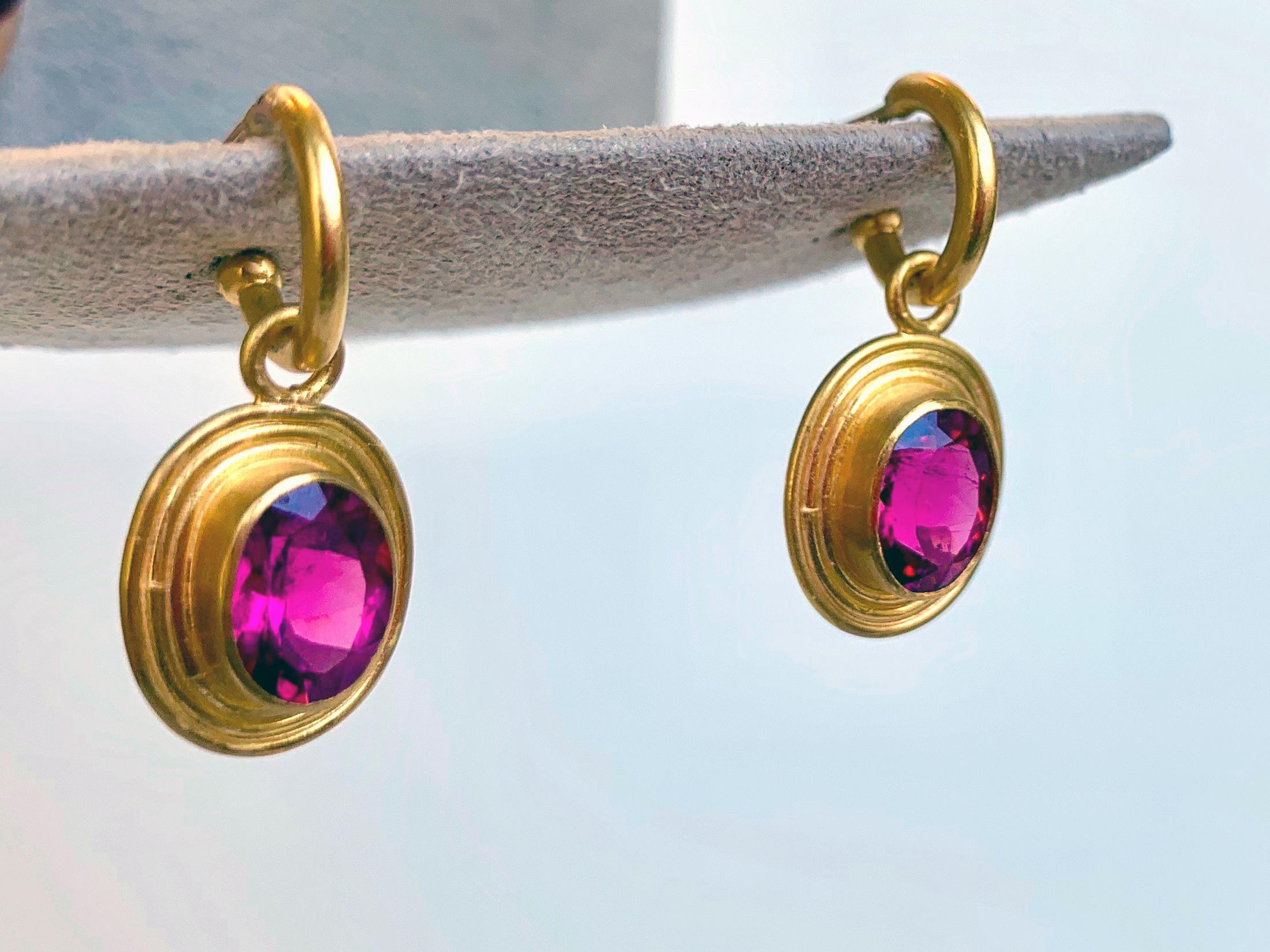 Stunning faceted rubellite stones totaling 3.86 carats are set in 22 karat gold round wires, inspired by ancient Roman jewelry design. hang on a 22 Karat gold hoop. Rubellite is a part of the Tourmaline family, ranging from pinks to 