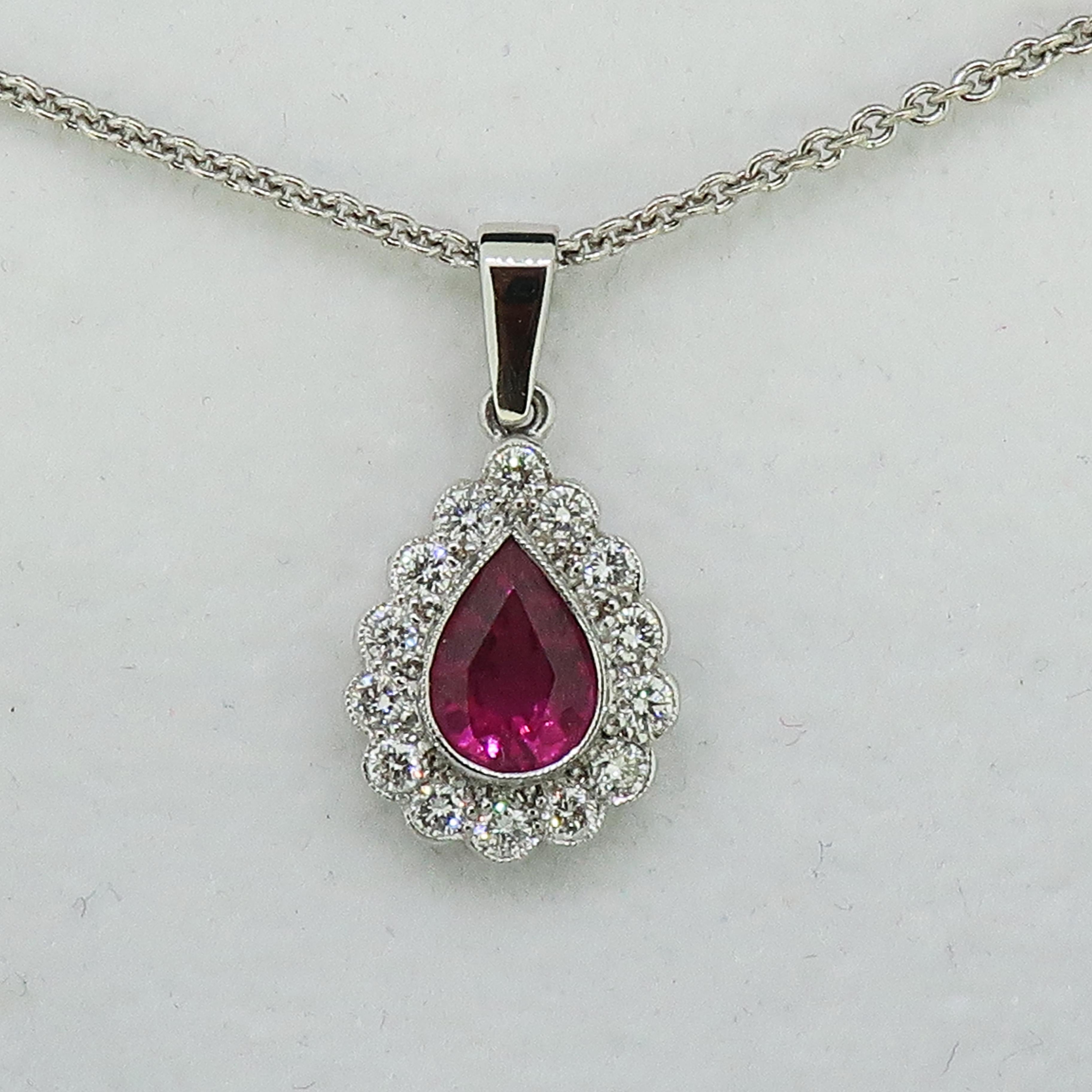 Rubellite and Diamond Pendant 18 Karat White Gold 

Vibrant pink rubellite and diamond pendant. Bright pink pear shape tourmaline / rubellite measuring 7.5mm x 5.3mm, encased in a white gold setting, surrounded by fourteen white brilliant cut