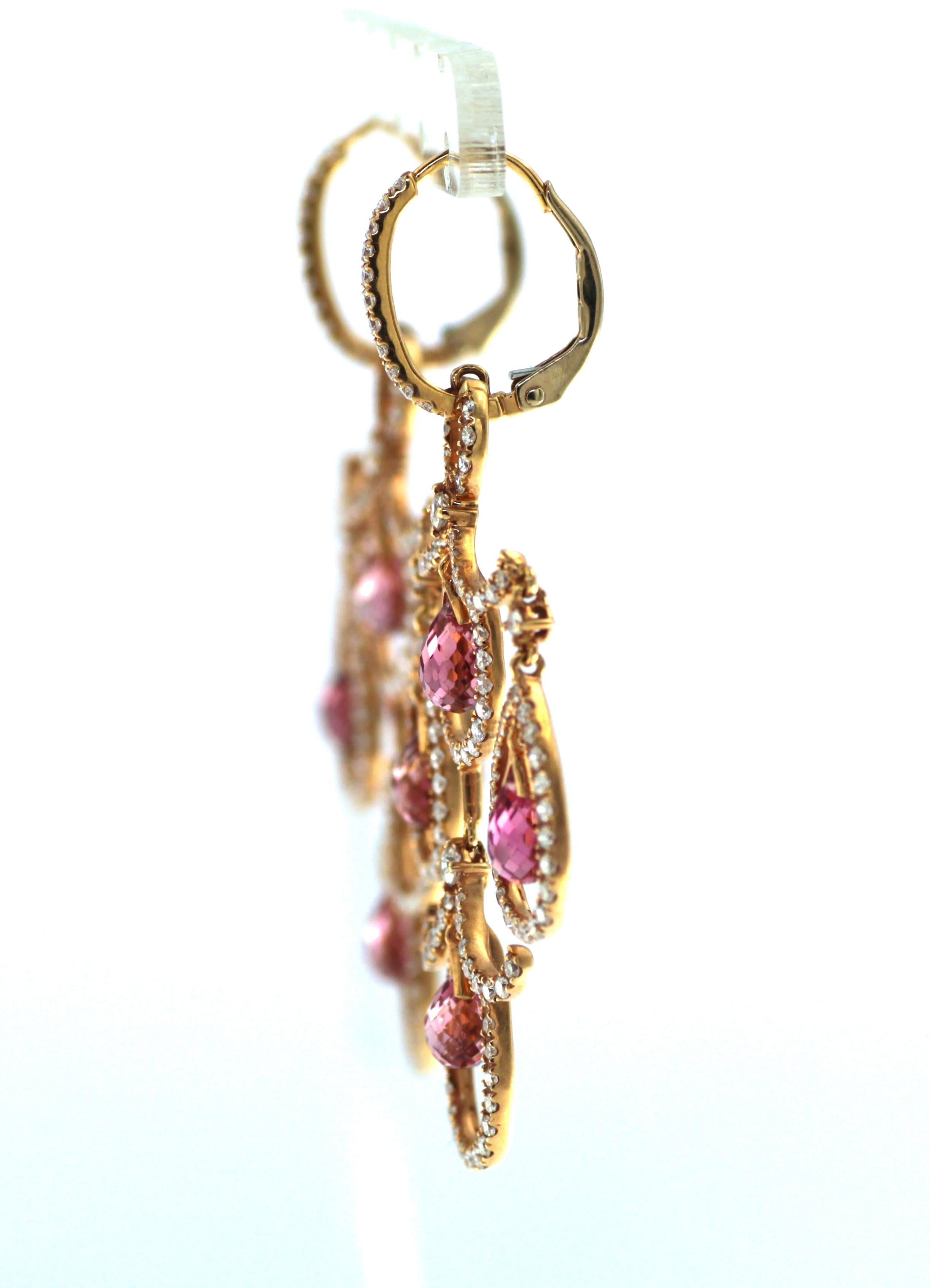 Introducing our Art Deco-inspired 18 karat rose gold earrings, a stunning statement piece that is sure to capture attention. These earrings feature a breathtaking 7.35 carat rubellite briolette that hangs elegantly from the ear, accentuated by a