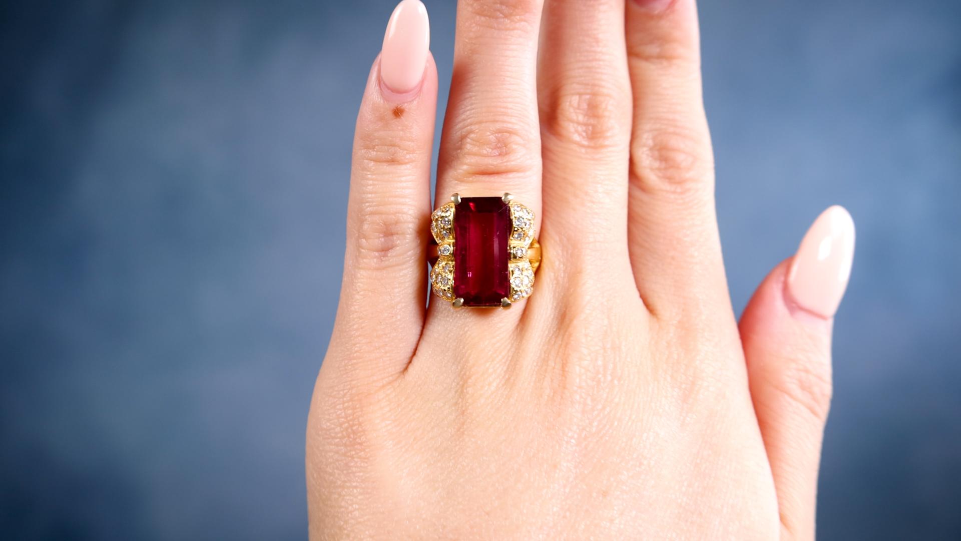 One Rubellite Diamond 18k Yellow Gold Ring. Featuring one octagonal step cut rubellite of 6.42 carats. Accented by 40 round brilliant cut diamonds with a total weight of 0.54 carat, graded near-colorless, VS clarity. Crafted in 18 karat yellow gold