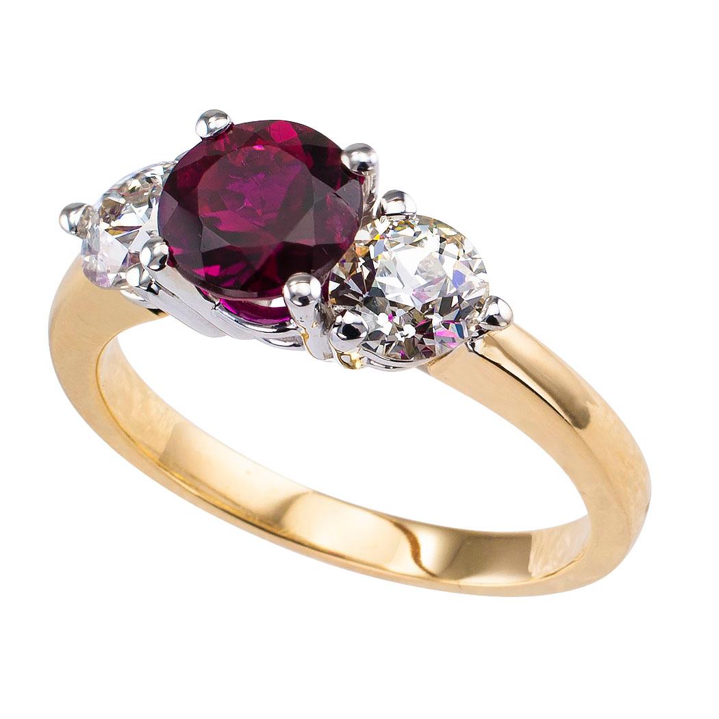 Rubellite and diamond three stone gold ring. Centering upon a round rubellite tourmaline weighing approximately 1.35 carats, flanked by a pair of old European-cut diamonds totaling approximately 1.20 carats, approximately J – L color and VS2 – SI2