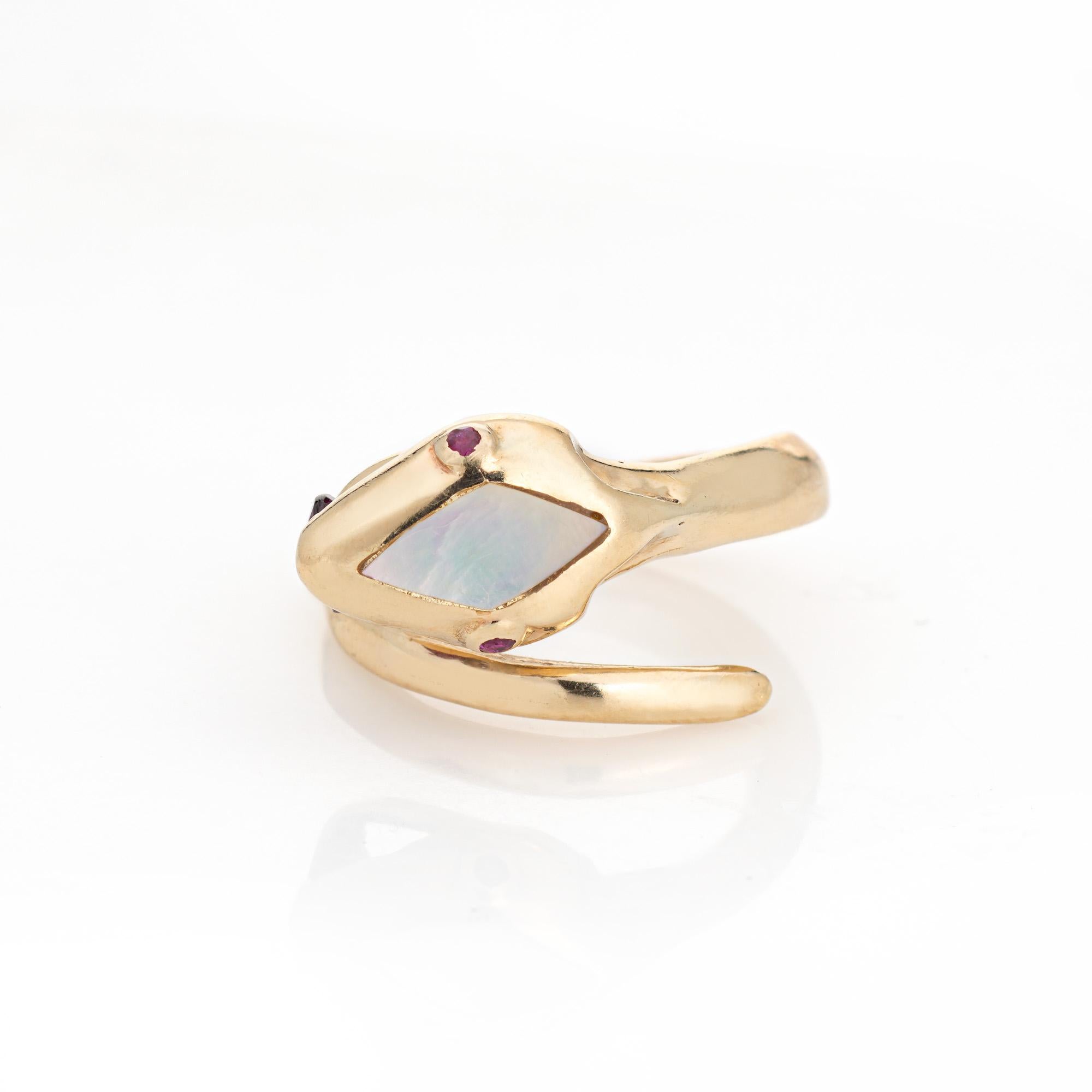 Finely detailed snake ring crafted in 14 karat yellow gold (circa 2000s). 

Two small estimated 0.01 carat rubellites are set into the eyes and one 5mm rubellite is set into the mouth. Mother of pearl is inlaid into the head (9mm x 4.5mm).     