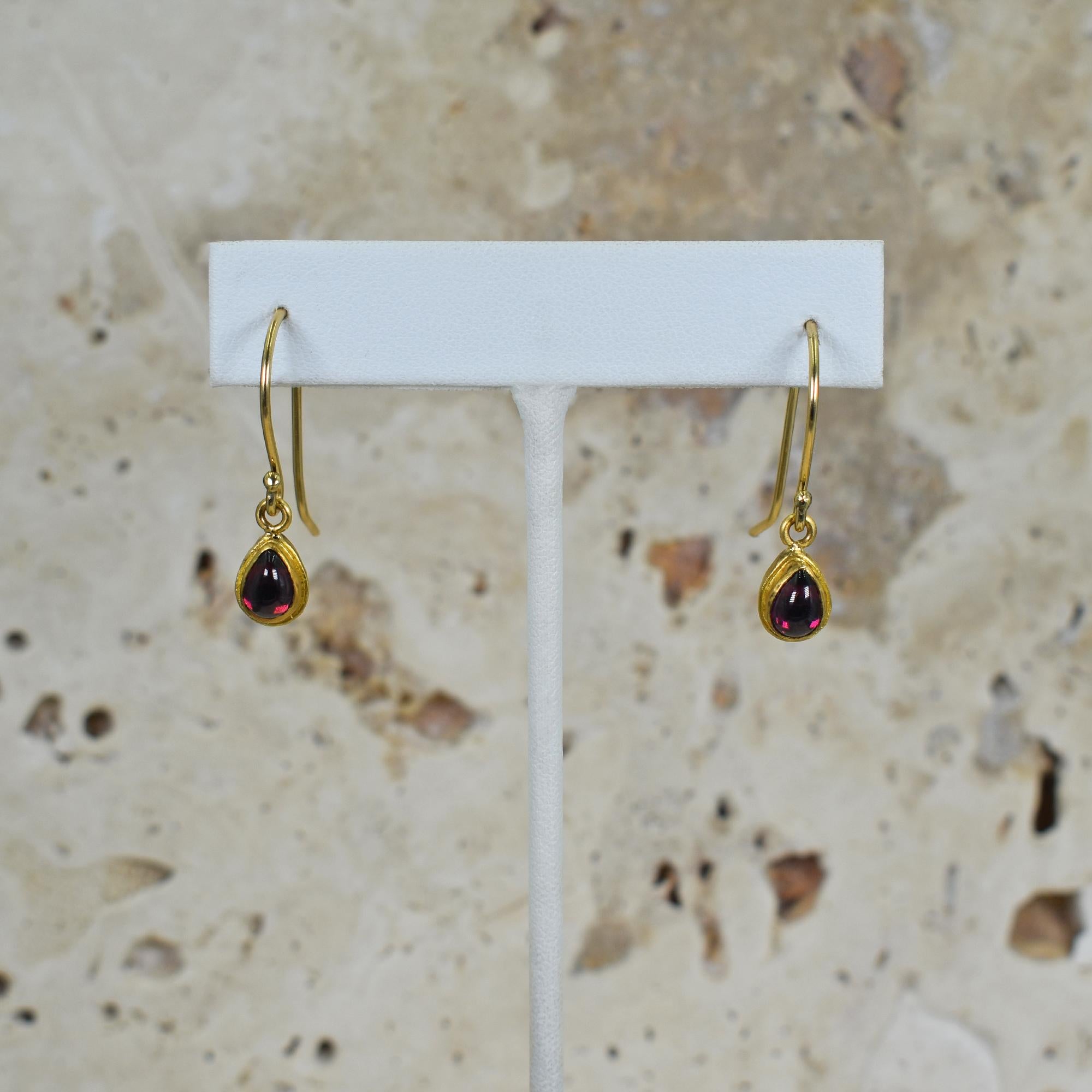 1.02 total carat red Rubellite Tourmaline tear drop / pear-shaped cabochon gemstones in 18k yellow gold bezel dangle earrings. Dangle earrings measure 1.07 inches in length. Contemporary, lightweight style of these earrings combined with the rich