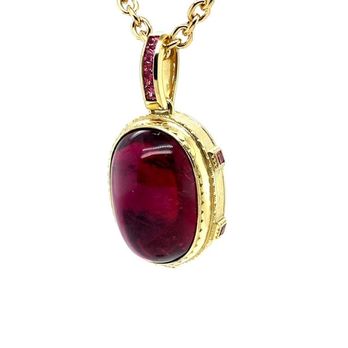 This giant rubellite tourmaline and spinel pendant features a spectacular 81.58 carat rubellite cabochon! The oval rubellite is a beautifully proportioned, crystalline gem that displays vibrant reddish pink and purplish pink color, depending on the