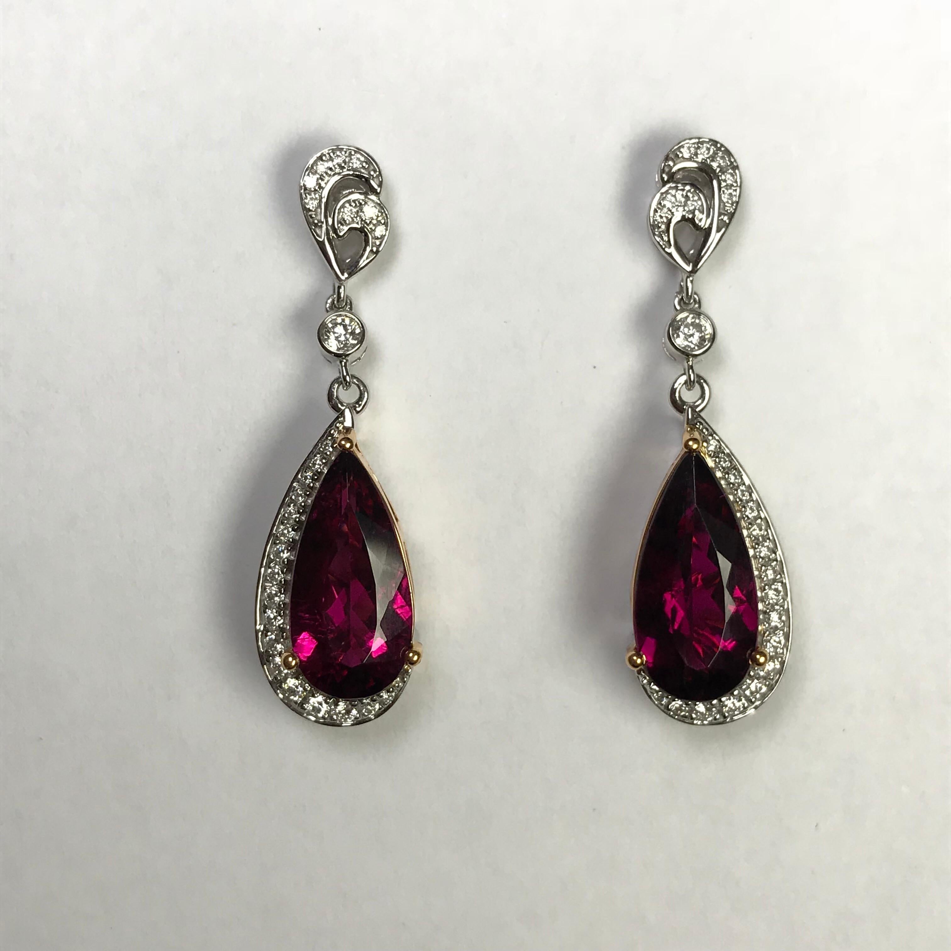 Double-pear stylized heart motifs suspend pear-shaped rubellite tourmalines that are cradled within hook-shaped frames of diamond. The tourmalines are set with rose gold prongs and mountings to strengthening the illusion that only the partial frames