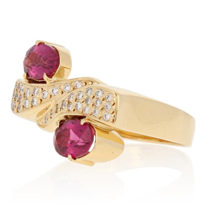 Ravishing beauty! Artistically crafted in 18k yellow gold, this luxurious bypass ring showcases two berry pink rubellite tourmalines set on either end of a tapered golden wave duo sparkling with white diamonds. 

This ring is a size 8, but it can be