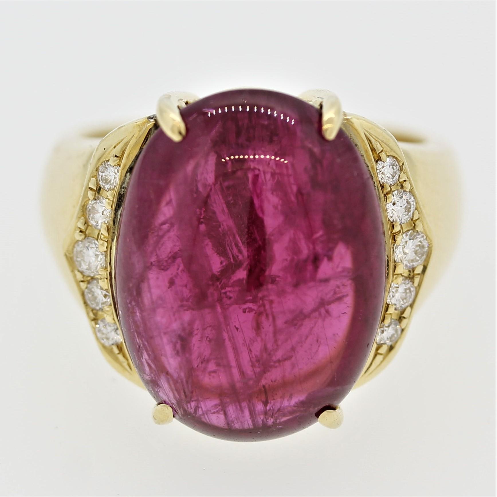A simple yet chic ring featuring a bright red tourmaline. The red tourmaline, known in the trade as rubelite, is cut as a cabochon and weighs 13.66 carats. It is a fine red color rarely seen in other gemstones. It is accented by 0.20 carats of round