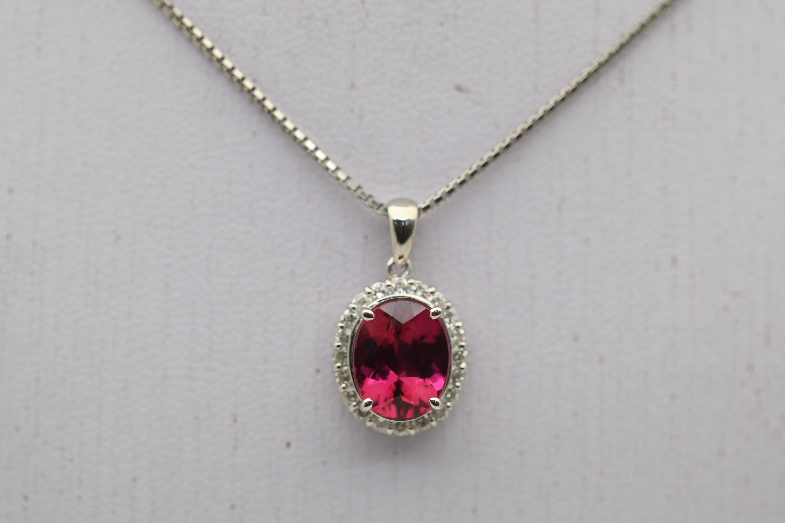 Una bellissima tormalina rubellite rosa-rossa del peso di 2,56 carati fa bella mostra di sé su questo pendente in platino. Il cristallo della tormalina è molto pulito e permette al ricco colore di diffondersi brillantemente sulla pietra. È