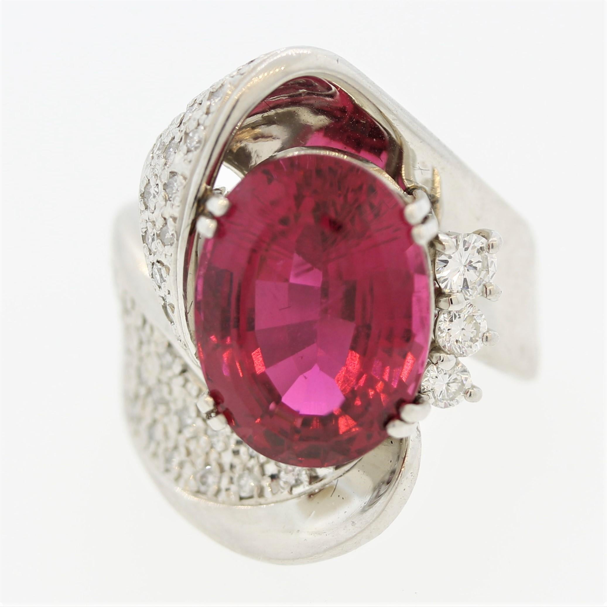 A fine tourmaline of the red rubellite variety takes center stage of this unique platinum ring. The tourmaline is cut as an oval shape and weighs an impressive 8.47 carats. It has a fine bright red color and is free of any major inclusions. It is