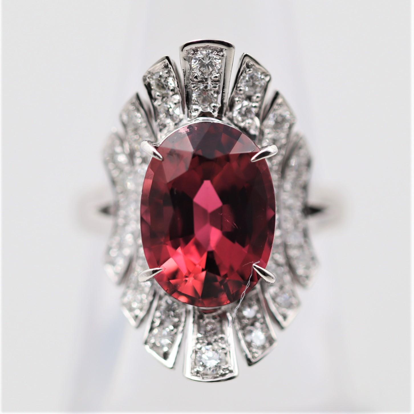 A sublime 5.26 carat oval-shape tourmaline takes center stage of this platinum made ring. It has a rich and vibrant slightly pinkish-red color. It is accented by 0.60 carats of diamonds set around the gemstone which add sparkle and brilliance to the