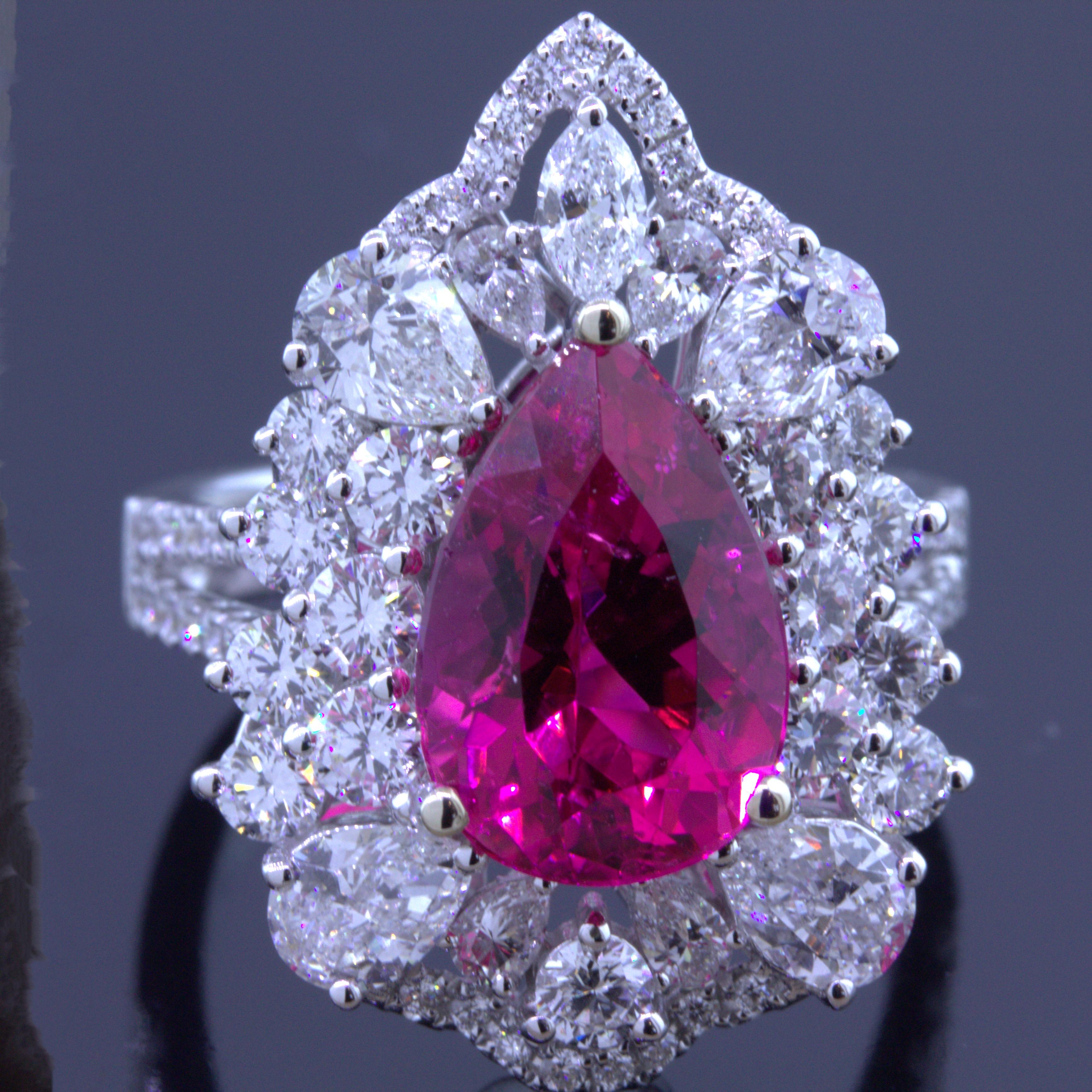 A super gem rubellite weighing 4.16 carats takes center stage. It is cut as a brilliant pear-shape and has a juicy and vibrant slightly pinkish-red color that will make you smile. The gem is full of light and brilliance. It is complemented by 2.91