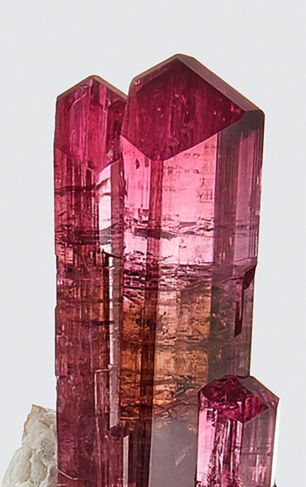 Tourmaline rubellite sur feldspath, champ de pegmatite de Malkhan, Krasnyi Chikoy, Kraï Zabaykalsky, Russie
Mesures : 8 cm de haut x 8 cm de large

Toutes les tourmalines rubellite sont comparées à la célèbre mine de Jona, au Brésil, qui détient