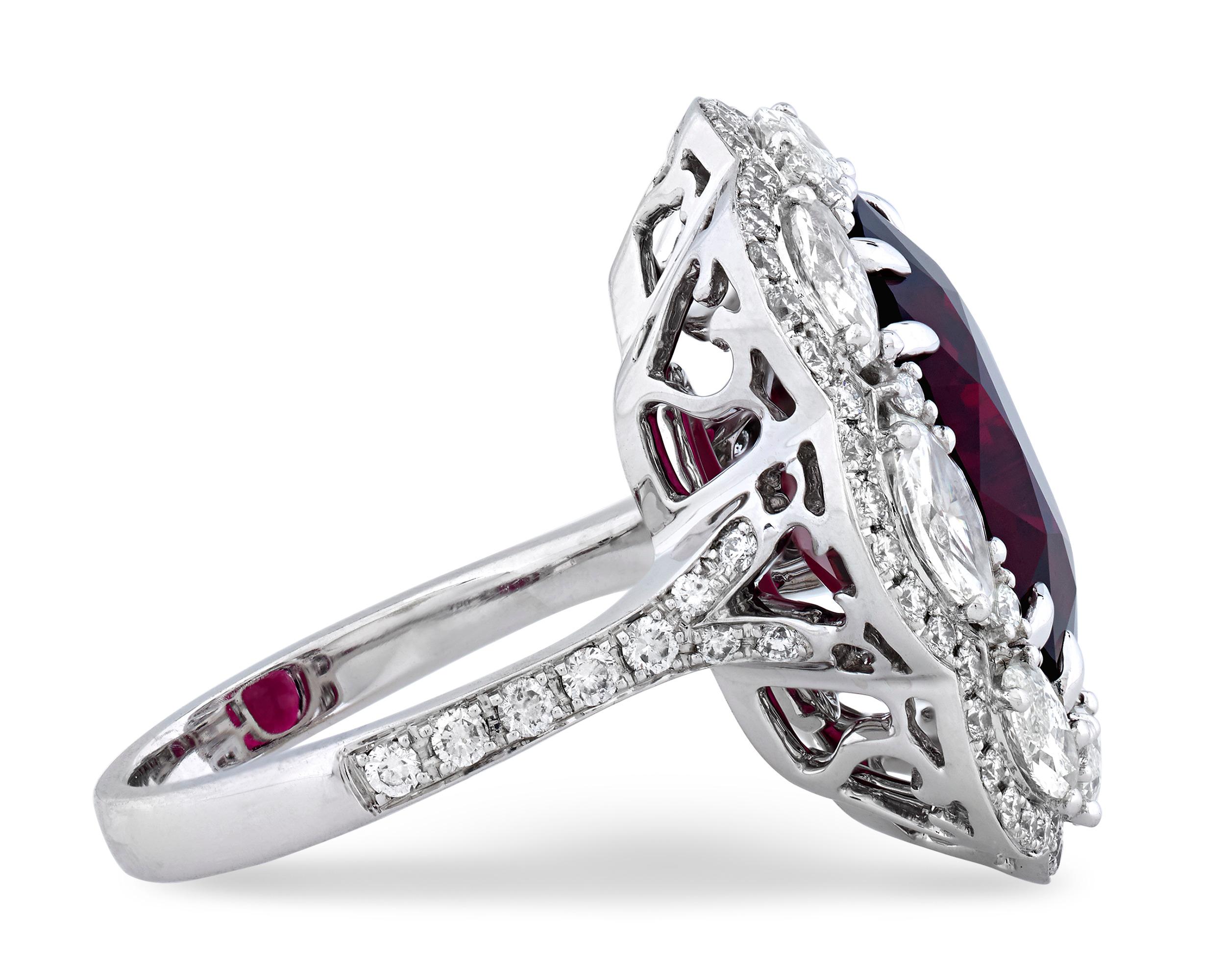 A rare rubellite tourmaline with a richly saturated crimson hue is at the center of this eye-catching cocktail ring. Weighing 9.52 carats, the cushion-cut gemstone is encircled by a halo of round and marquise-cut diamonds totaling 2.10 carats. Set