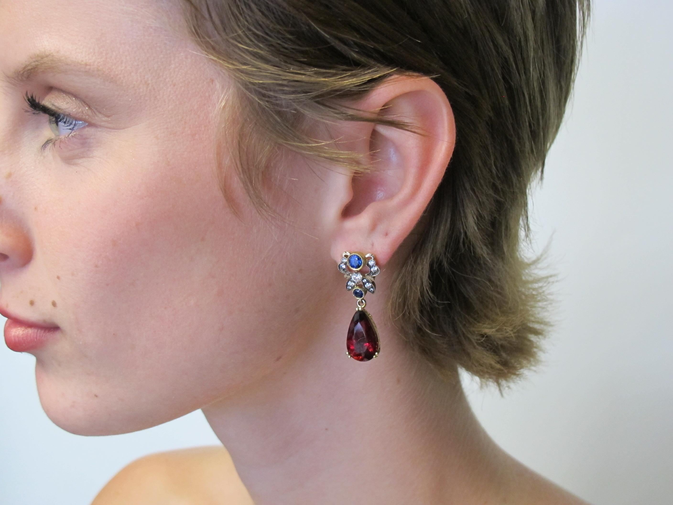 These butterfly inspired earrings feature rubellite tourmalines (16.34x9.64mm/11.70cts tw), blue sapphires (1.25cts tw), and white diamonds (0.60cts tw) set in a custom 18k white and yellow gold, hand engraved mounting. It is very unusual to see