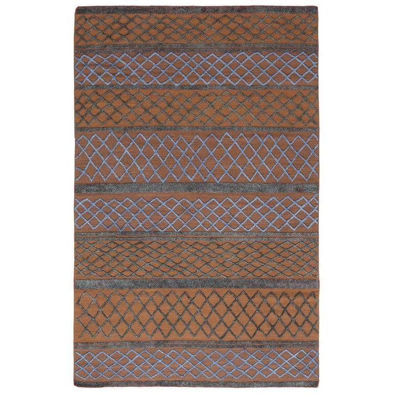 Designed by Stefania Crippa of Studio Contromano, this striking rug features horizontal lines, enclosing rows of diamond-shaped decorative patterns in blue and light blue over a rich shade of brown. This unique, modern piece is inspired by the works