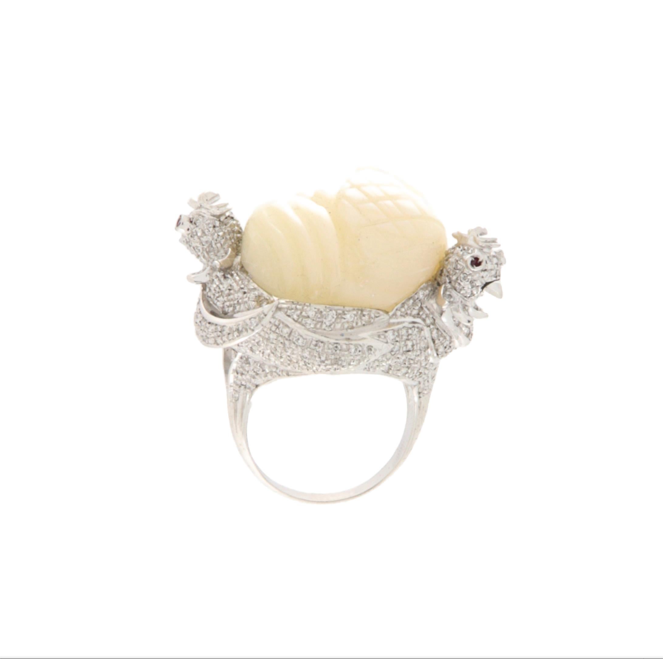 Dieser außergewöhnliche Ring aus 18 Karat Weißgold ist ein wahres Meisterwerk der Schmuckkunst, das elegantes Design mit raffinierten symbolischen Details verbindet. Seine Struktur zeichnet sich durch die originelle und auffällige Darstellung zweier