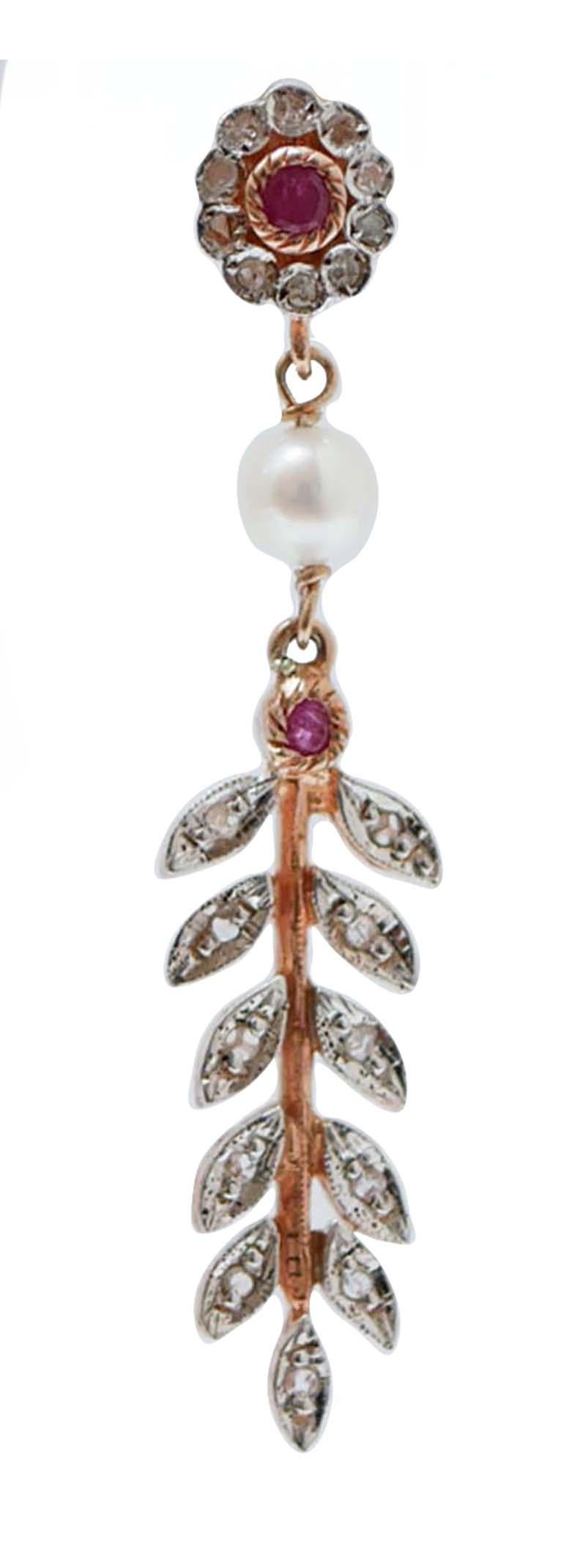 Amazing earrings in 9 kt rose gold and silver structure mounted with a flower of diamonds and a central ruby in the upper part. In the middle, a pearl and, below, a ruby  and a rain of leaves studded with diamonds.
These earrings were totally