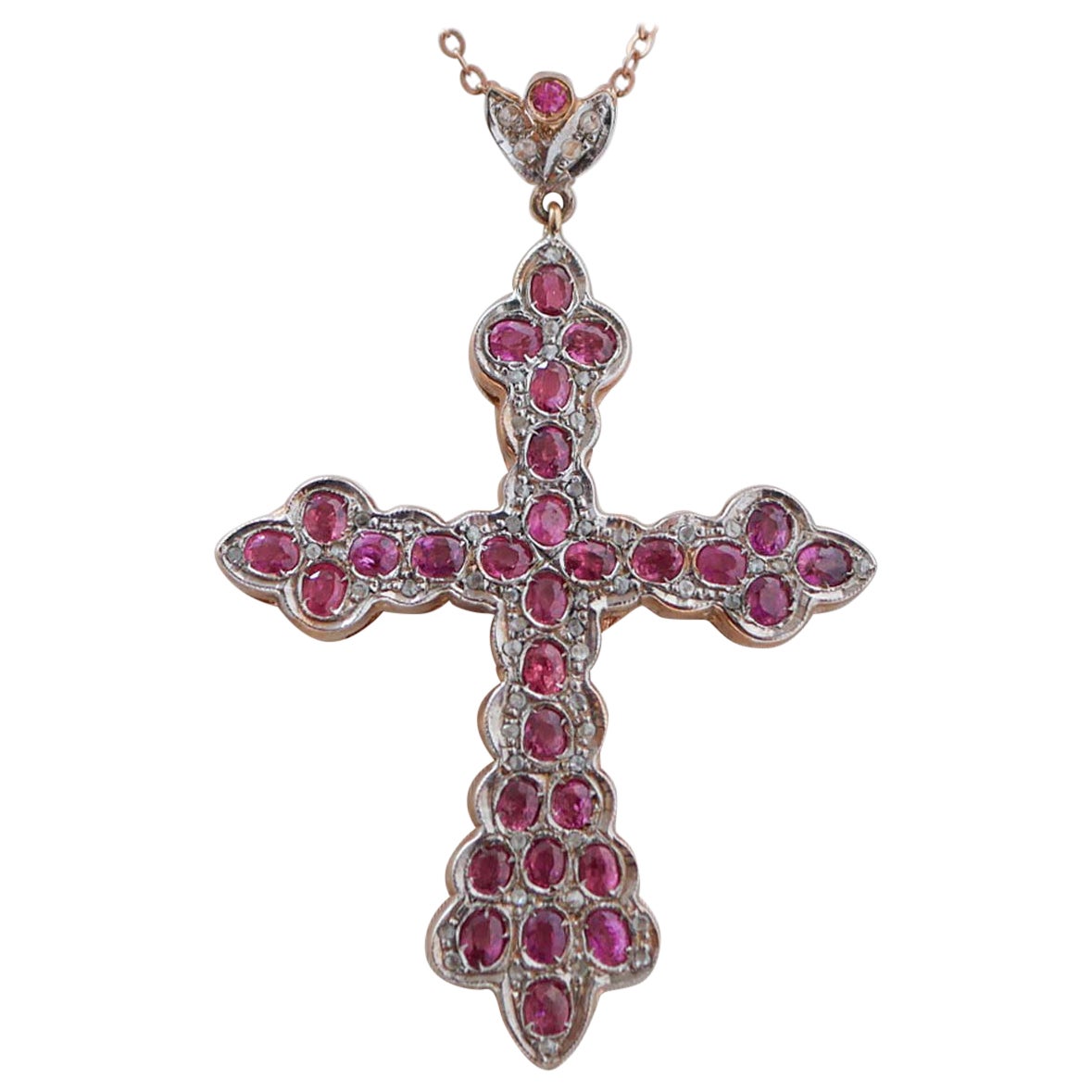 Ciondolo a forma di croce in oro rosa e argento con rubini e diamanti.