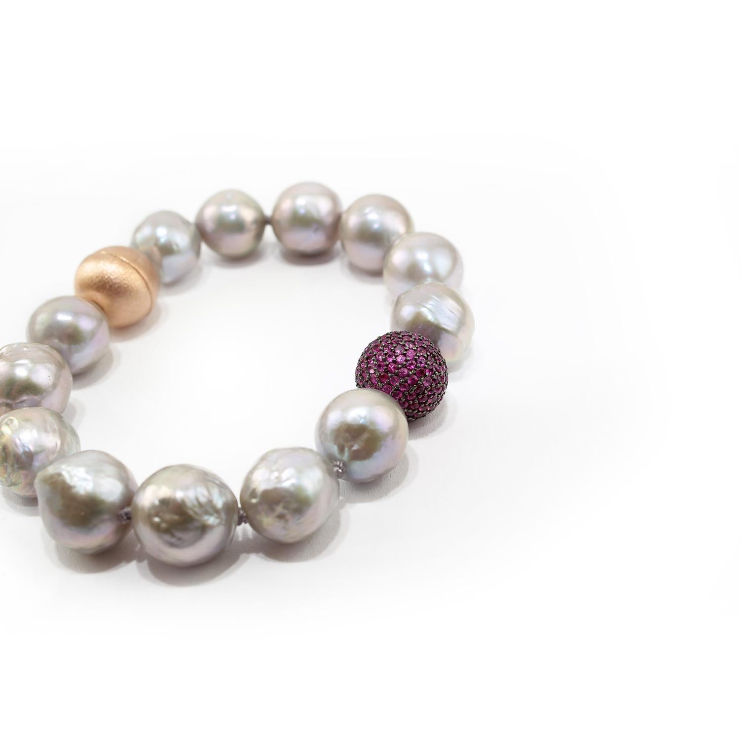 Nice bracelet made up of rubies pave on silver setting, baroque grey pearls and 925 satin silver clasp. 
Rubies pave ct. 2,26
Baroque grey pearls
925 satin pink silver clasp (magnet system)
Total lenght (including clasp) is cm 18,5