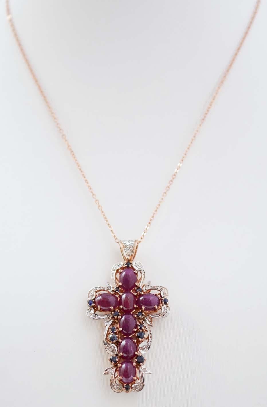 Retrò cross pendant in 9 kt rose gold and silver structure mounted with rubies in the central part surrounded by diamonds and blue sapphires. The silver chain is included.
This pendant was totally handmade by Italian master goldsmiths and it si in
