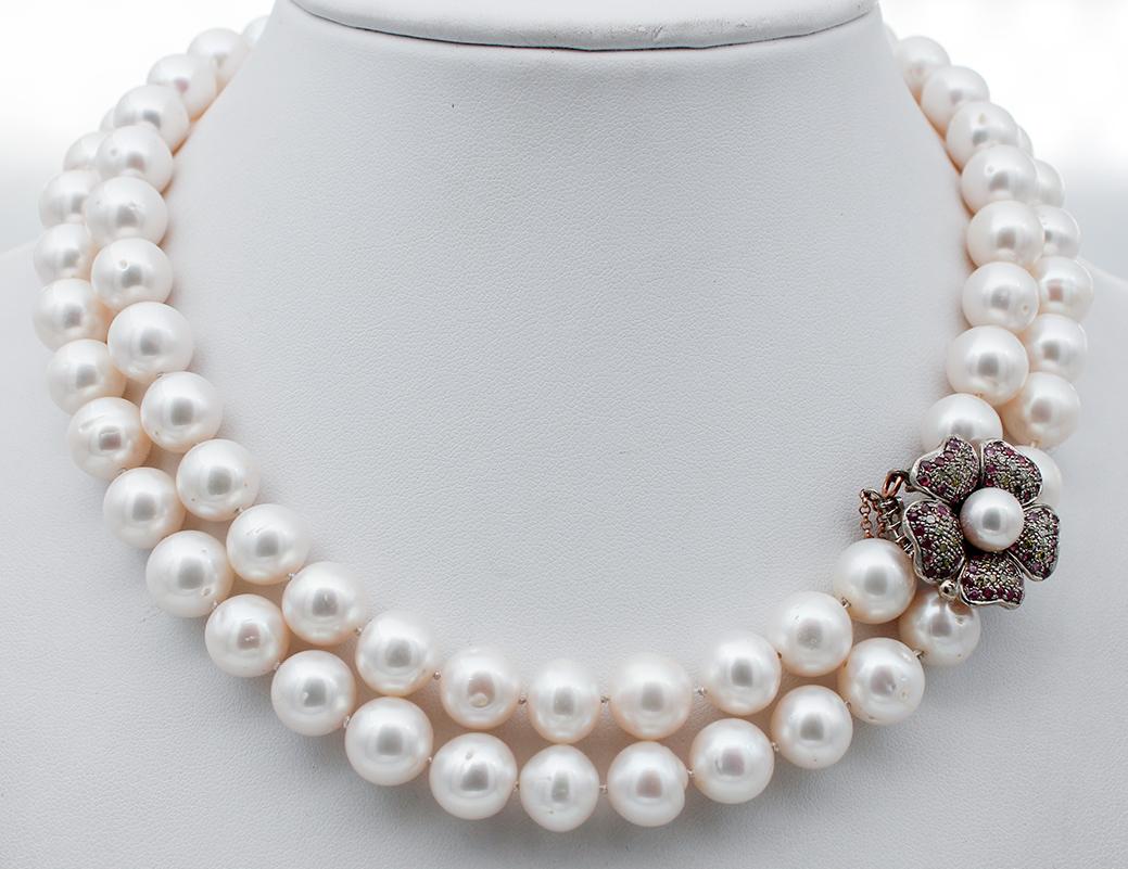 Wunderschönes Collier mit zwei Perlenreihen und einem blumenförmigen Verschluss aus 9 Karat Roségold und Silber mit einer zentralen Perle, die von Steinen und Rubinen umgeben ist.
Diese Halskette ist vollständig von italienischen