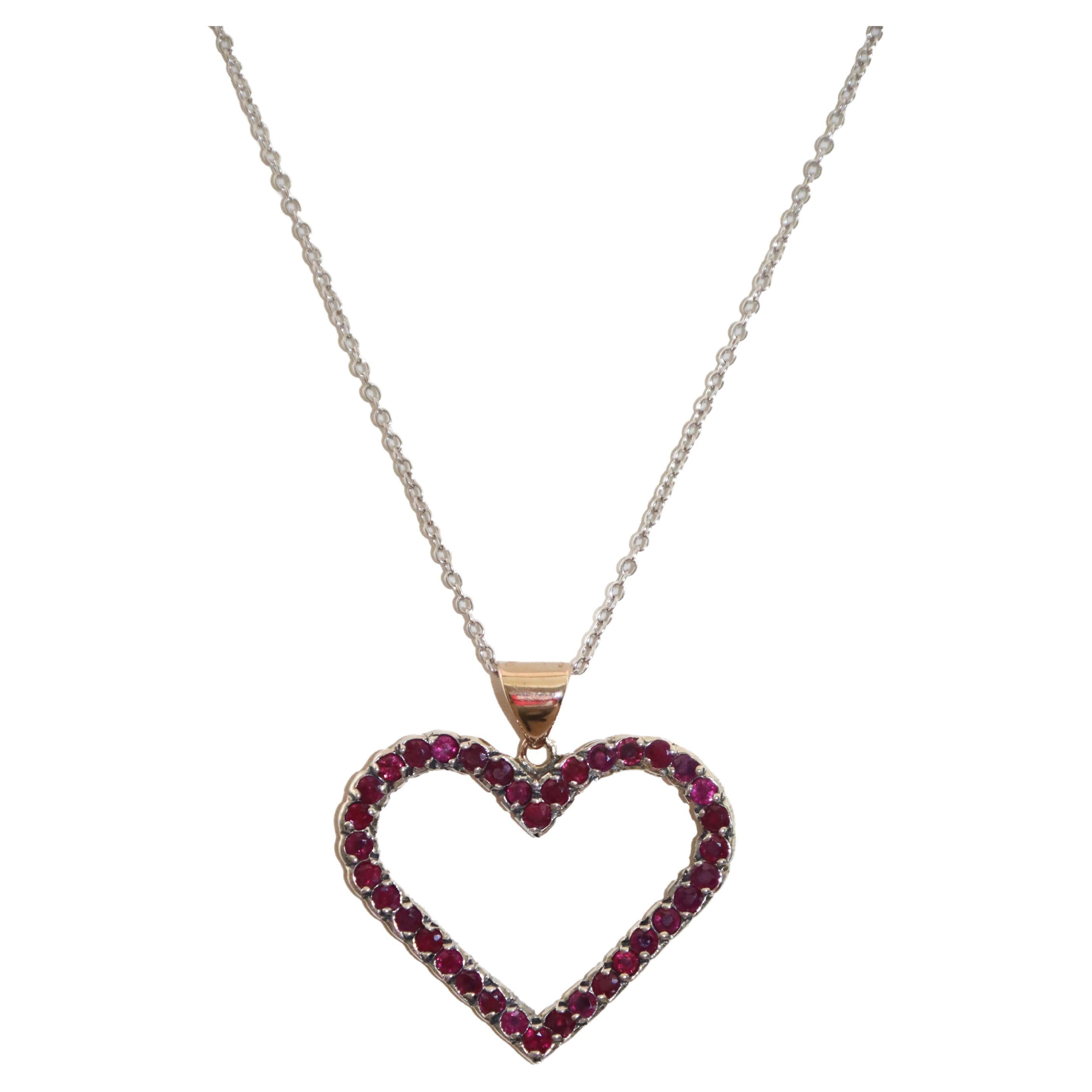 Elevate your jewelry collection with this stunning heart-shaped pendant, a masterpiece crafted in 9 kt yellow gold and 800 silver. This elegant creation combines timeless design with luxurious materials, offering a striking balance of warmth and