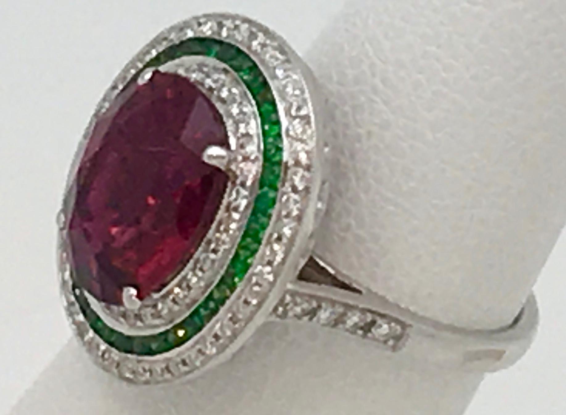 The 4.37 Carat (Scale Weight) Rubilite Tourmaline also has 82 Diamonds for .40 Carats(Scale Weight) and 35 Round Faceted Emeralds for .36 Carats(scale Weight)The gemstones are set in 18KT White Gold.