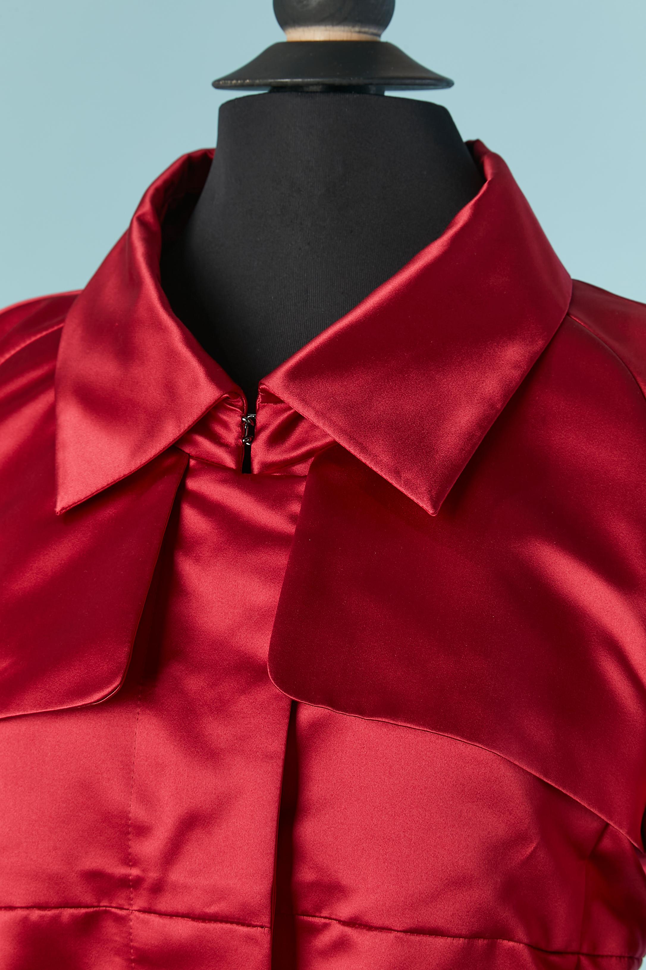 Rubis red satin trench-coat . Fabric composition: 41% silk, 59% polyester. No lining but piping. Raglan sleeve. Pocket on both side. Branded button and buttonhole closure on the middle front ( hidden) + hook&eye on the collar. Fabric Belt and silver