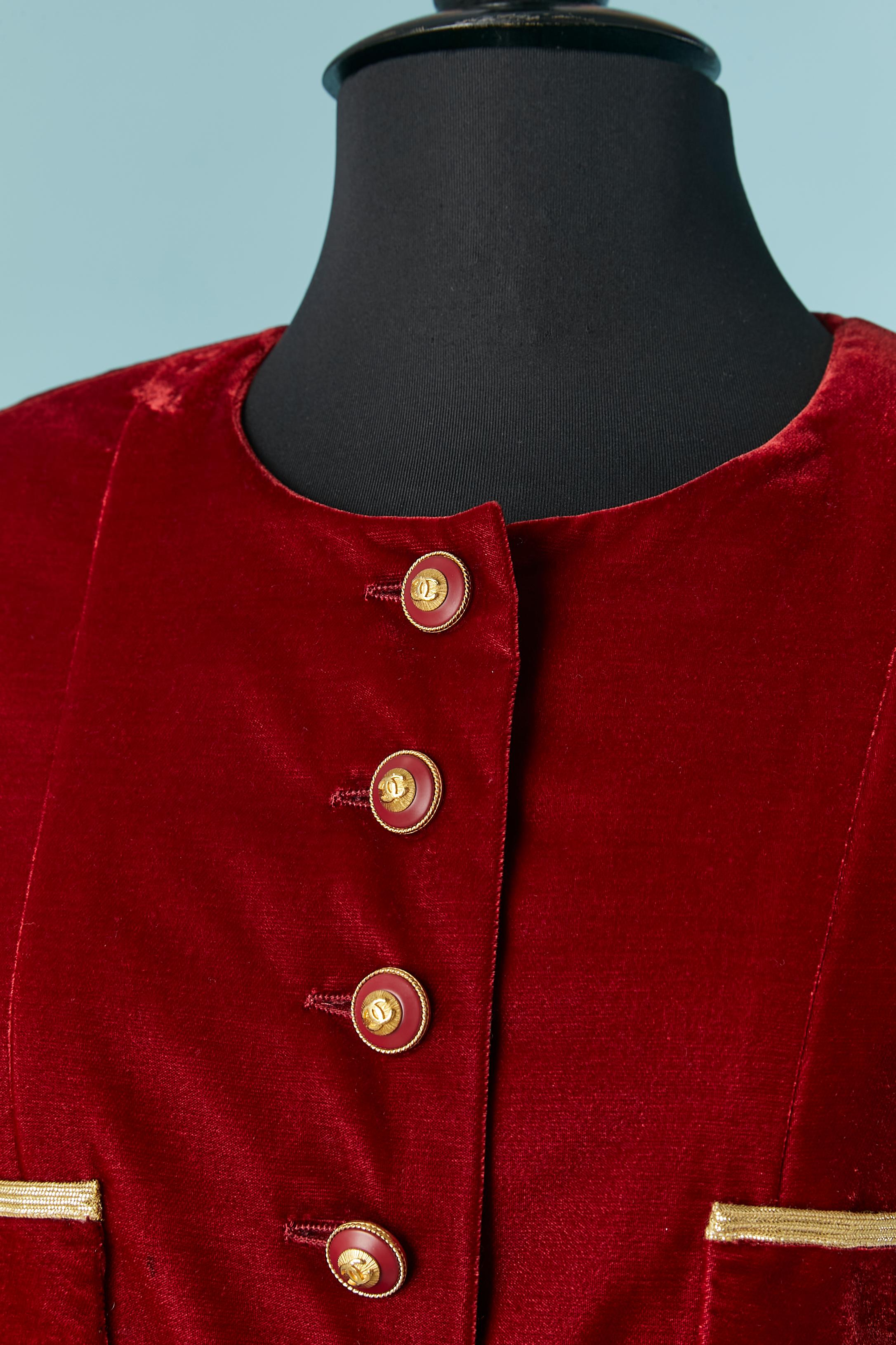 Rubis red velvet long jacket with branded button and gold braid piping. 
Shoulder pad. Pocket on both side. 
FW 1993
SIZE 40 (Fr) M/L 