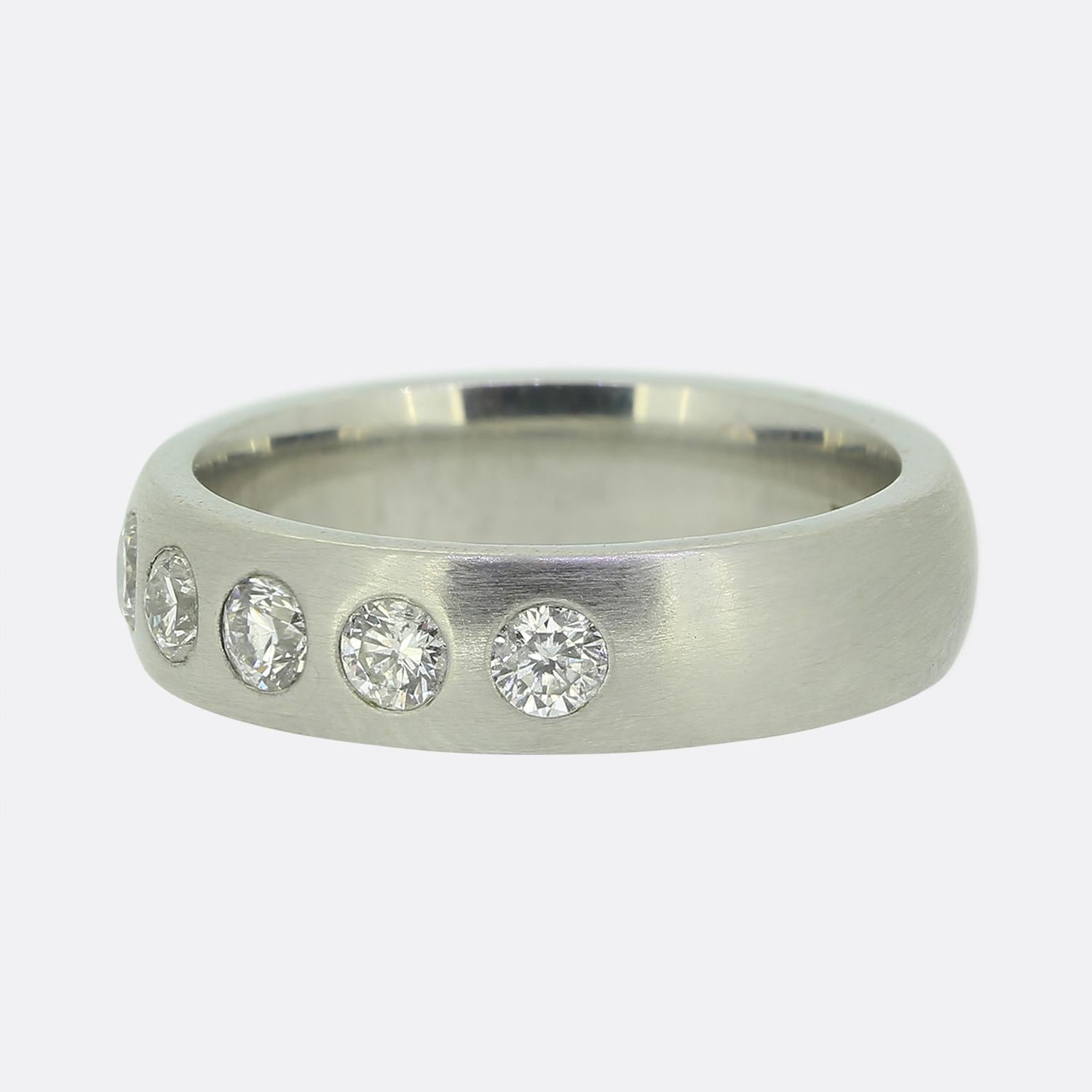 This is a platinum rubover set diamond band ring. The ring plays host to 9 round brilliant cut diamonds that are spread equally across half of the band.

Condition: Used (Excellent)
Weight: 10.0 grams
Size: L 1/2
Band Width: 5mm
Total Diamond Carat