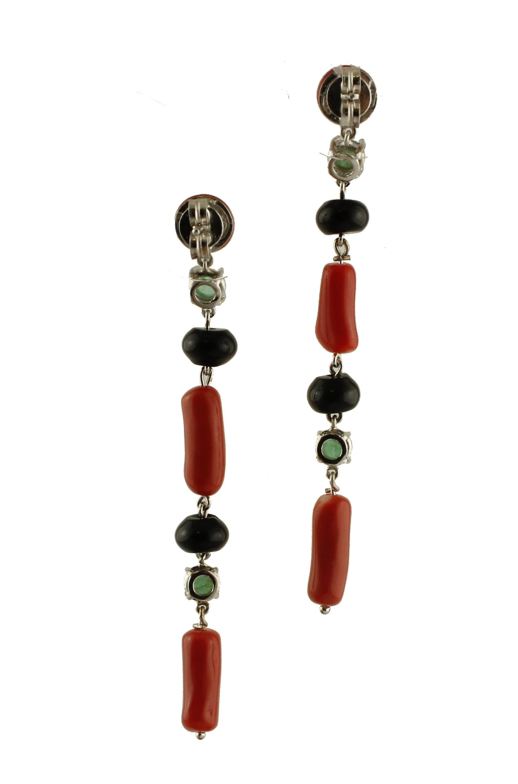 Lovely dangle earrings in 14k white gold, made of red rubrum coral, emeralds and onyx stones that interchange along the earrings. 
These earrings are totally handmade by Italian master goldsmiths
Emeralds 1.28 ct
Rubrum Coral 2.50 g
Onyx 1 g
Total