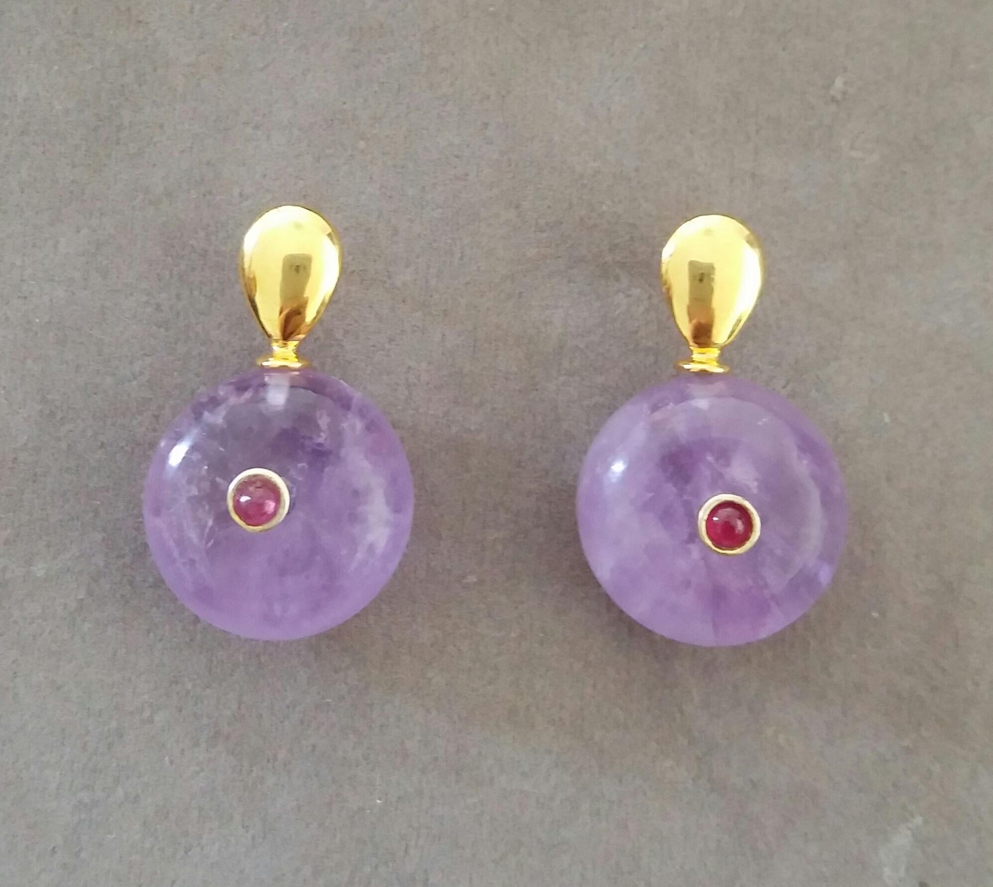 Simple chic stud earrings with a pair of Oval Cut Amethyst measuring 8mm x10 mm set in solid 14 Kt. yellow gold on the top and in the lower parts 2 Round Plain Wheel Shape Amethyst  16 mm .in diameter with a small round Ruby cab in the center
In