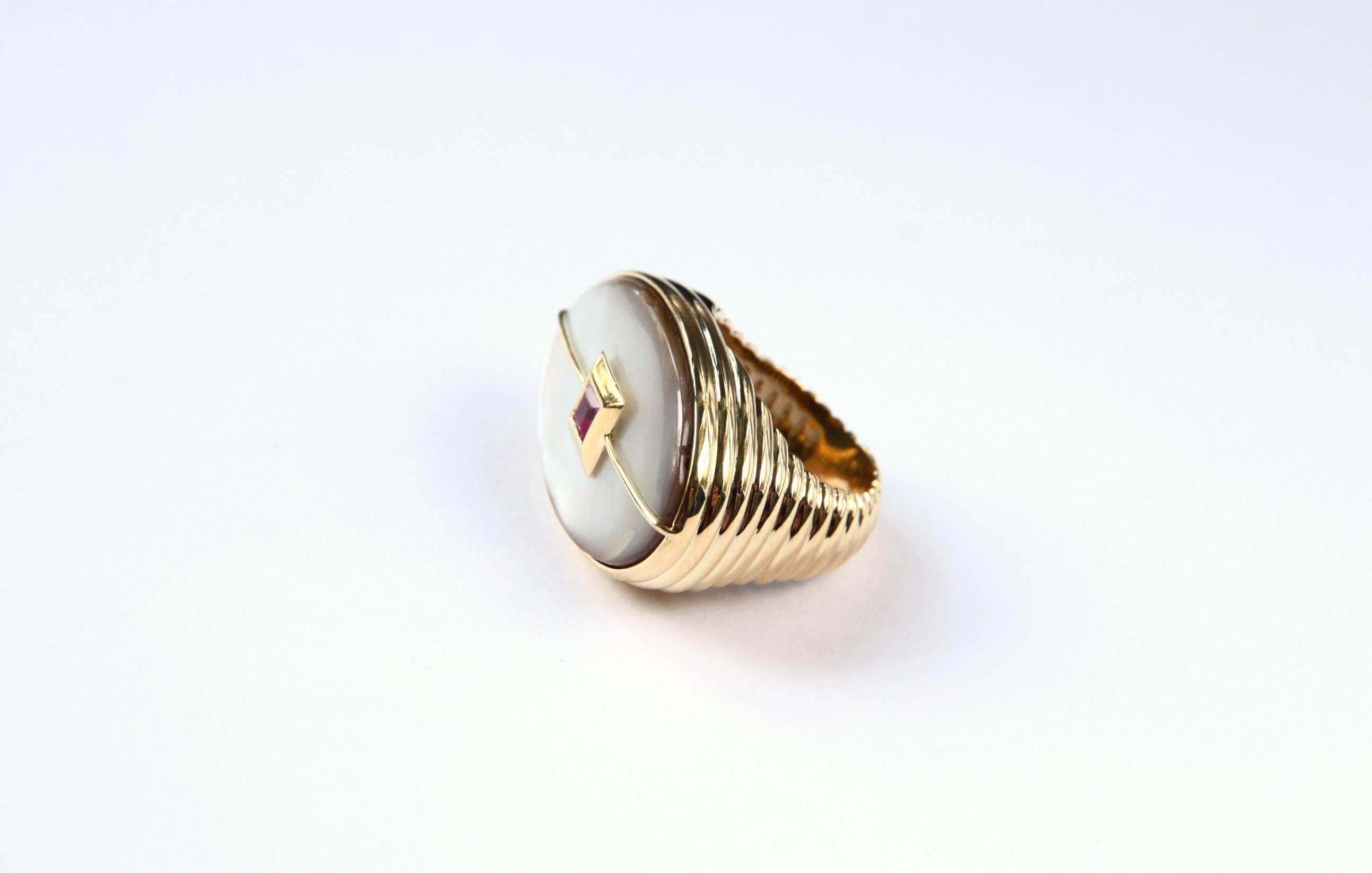 Very nice 18 kt gold gr.23,20 cocktail ring  with oval Lucent  mother of pearl in the center a ruby 0,55 CTS princess cut.
Very modern and essential design.
All Giulia Colussi jewelry is new and has never been previously owned or worn. Each item