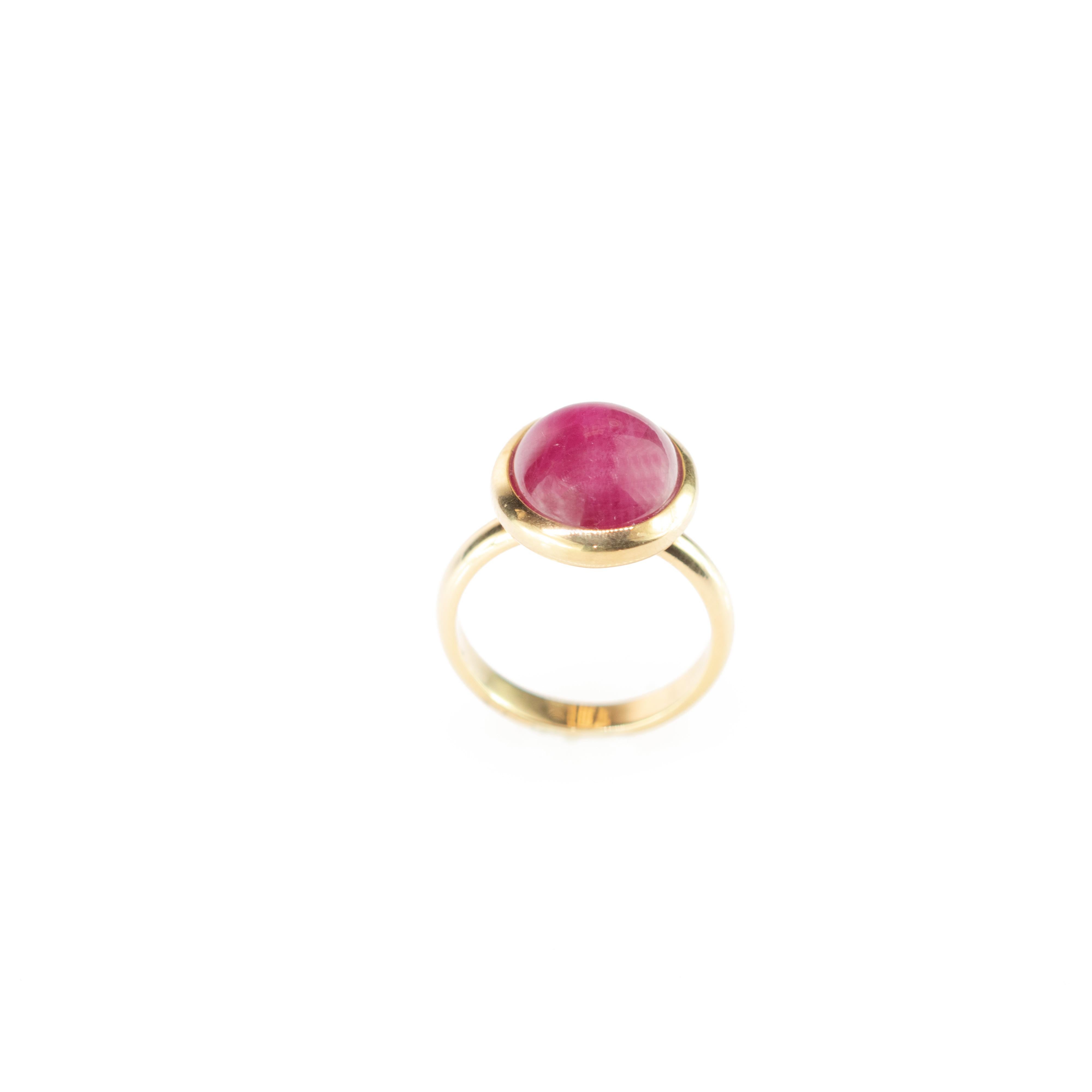 Delicate 18 karat yellow gold ring band with central purple ruby gem (11 g). A simple but exquisite solitaire design of an oval and cabochon cocktail jewel.
 
This ring is designed for the active and independent woman of the 21st century. Its bold